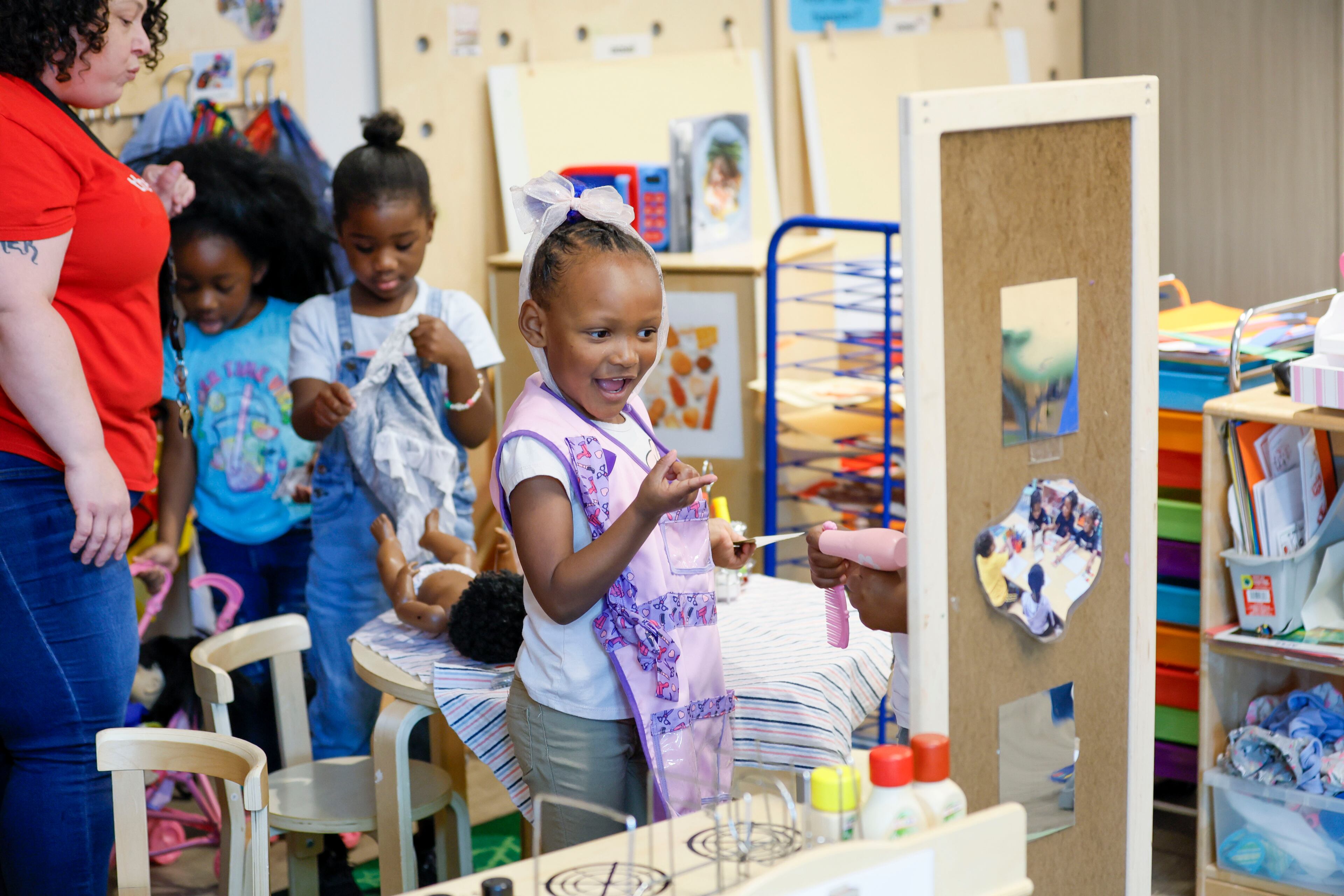 A child in the Head Start plays inside with lead teacher Genesis Lavanway at the Arthur M. Blank Early Learning Center on Monday. (Miguel Martinez/AJC)