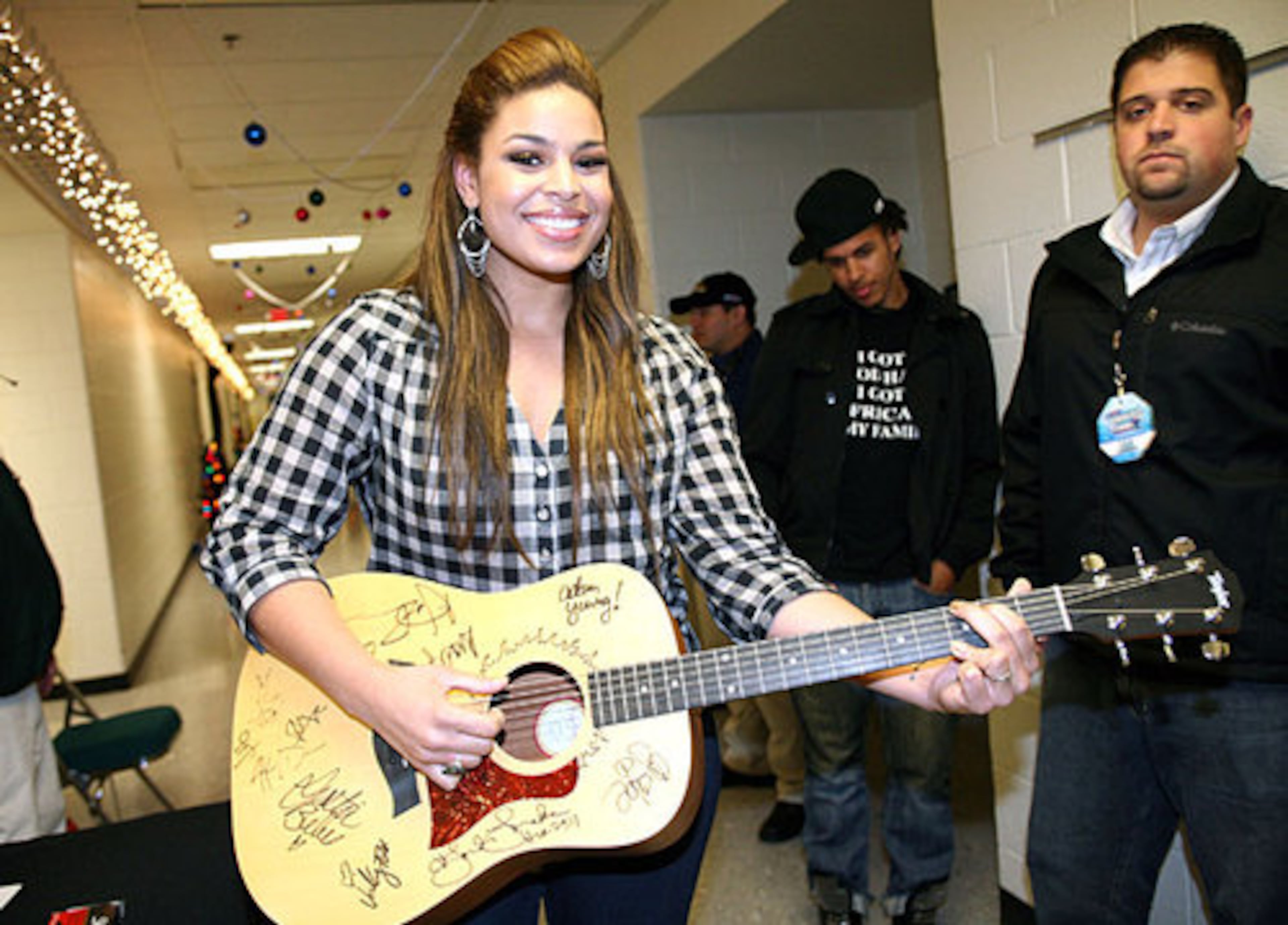 Jordin Sparks holds the guitar that all of the artists sign; it is then auctioned off and the proceeds benefit a charity supported by Star94.