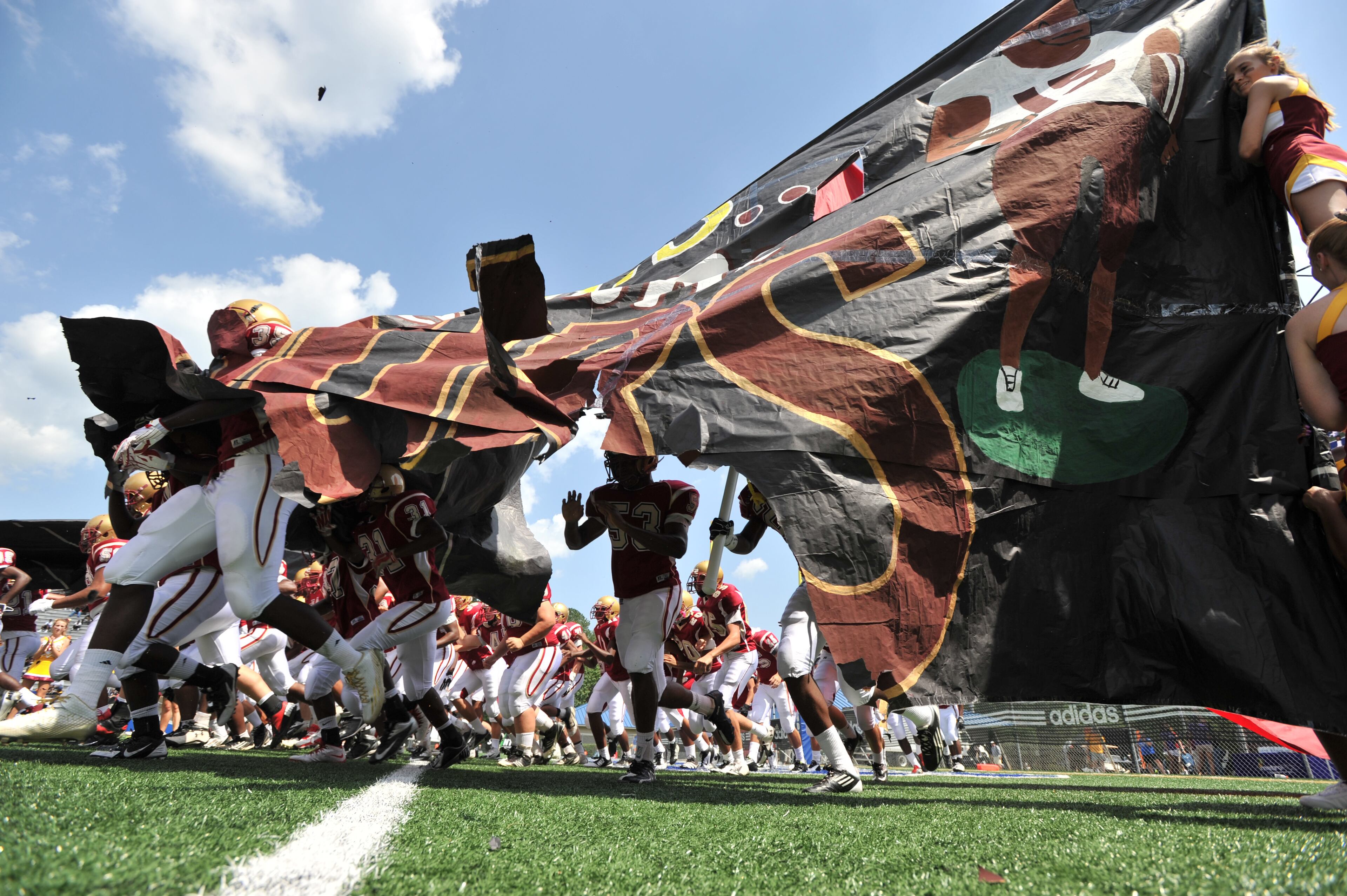 Brookwood players tear through a banner before their game against the Valdosta during the 2014 Corky Kell Classic at McEachern High School in Powder Springs on Saturday, August 23, 2014.