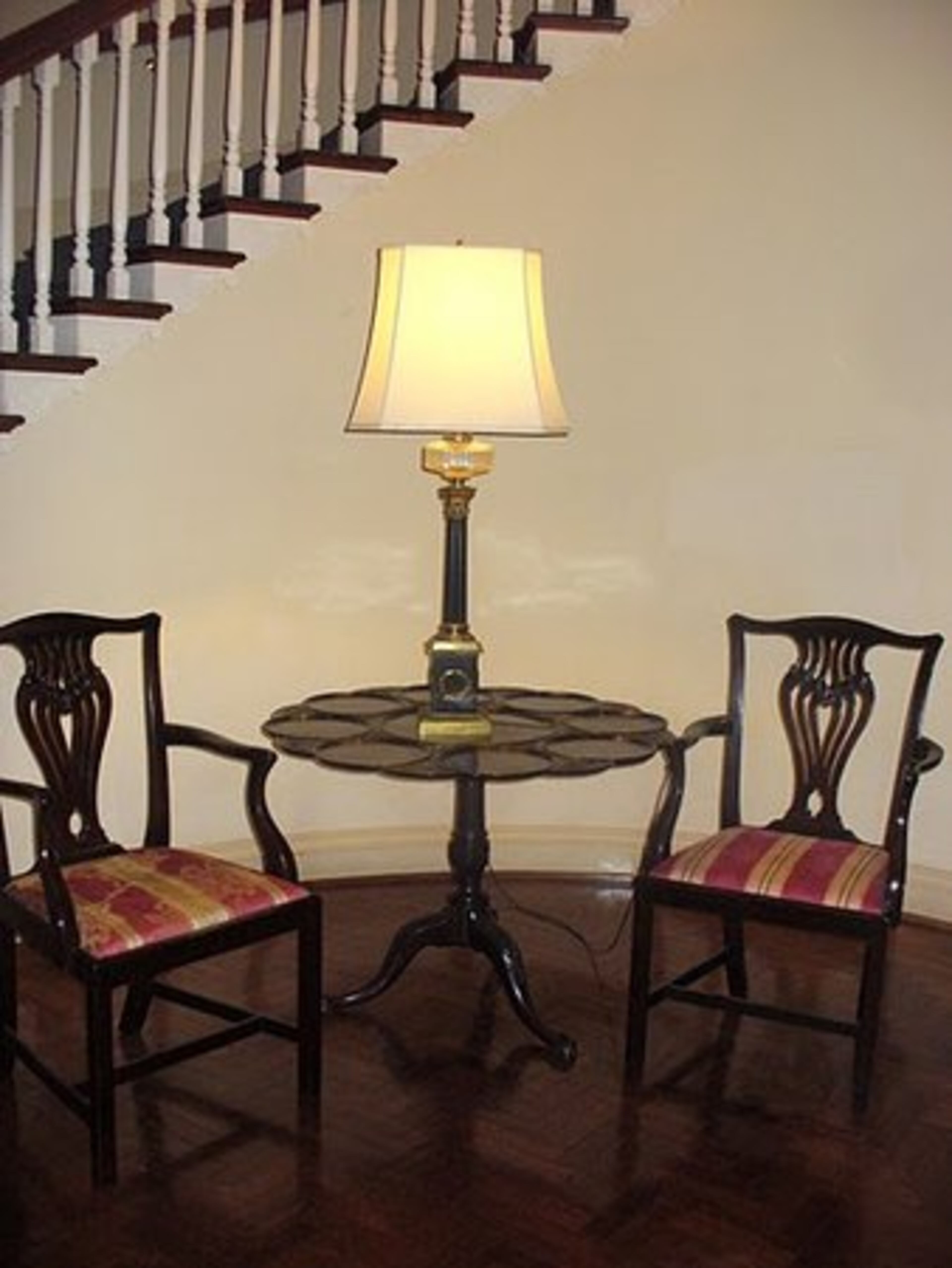 An antique English Chippendale-style supper table and pair of Chippendale arm chairs.