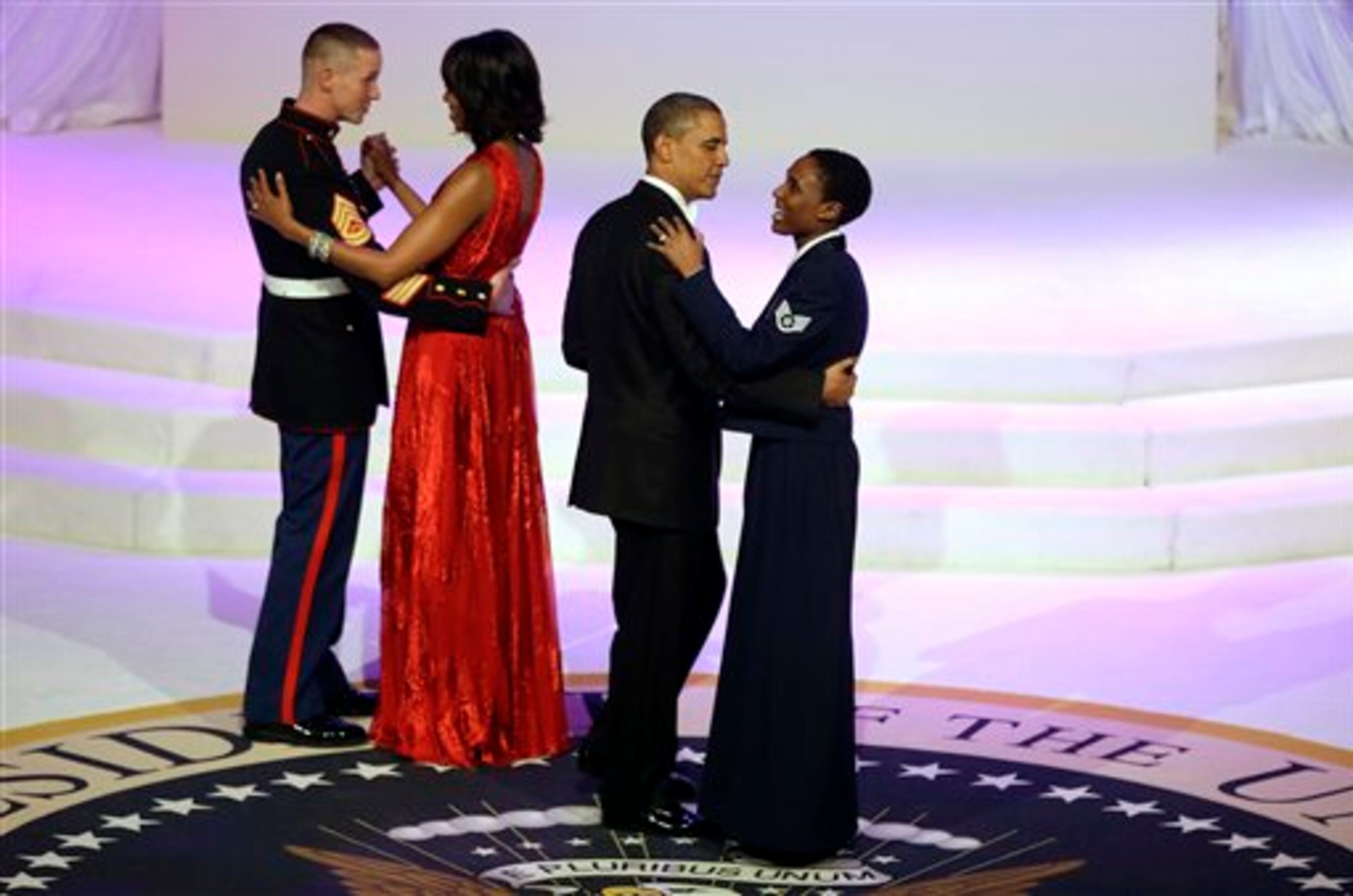 President Barack Obama and first lady Michelle Obama share a dance with Air Force Staff Sgt Bria Nelson and Marine Corps Gunnery Sgt. Timothy Easterling during the Commander-In-Chief's inaugural ball at the Washington Convention Center during the 57th Presidential Inauguration Monday, Jan. 21, 2013 in Washington. (AP Photo/ Evan Vucci)