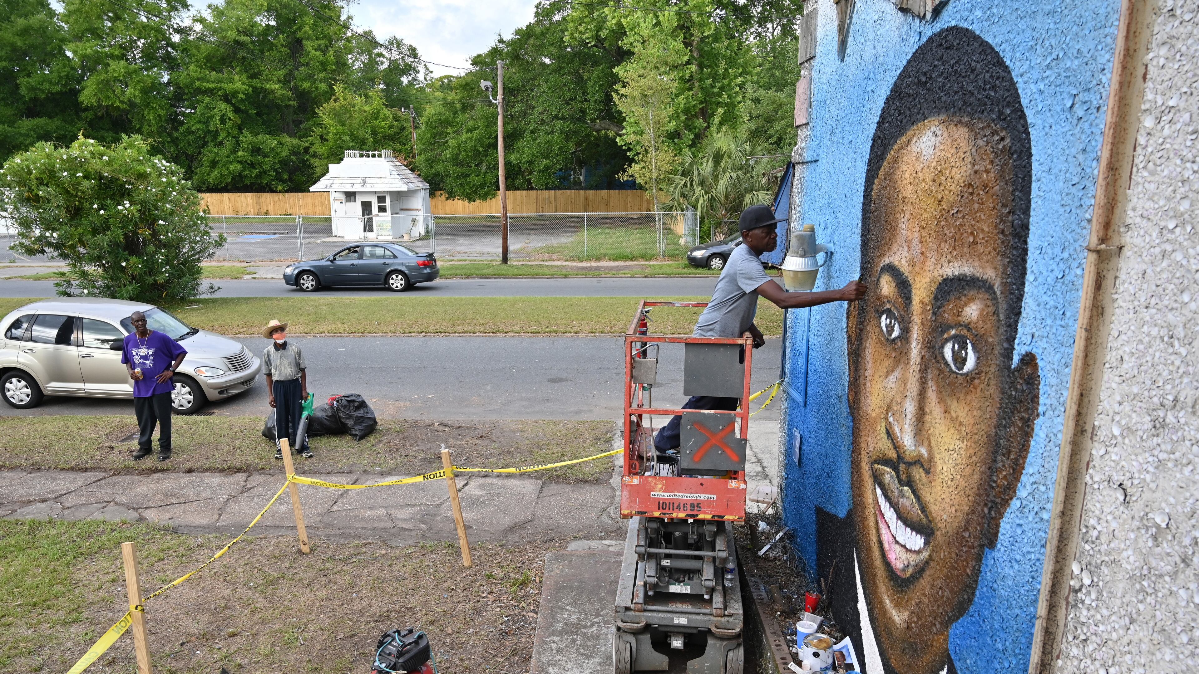 May 15, 2020 Brunswick - Miami based artist Marvin Weeks, who is originally from Brunswick, works on a large mural in tribute to Ahmaud Arbery on the side of a building which will soon be the site of the Brunswick African American Cultural Center in Brunswick on Friday, May 15, 2020. Ahmaud Arbery was shot Feb. 23 as he jogged through Satilla Shores, a mostly white community a few miles from his Brunswick home. Security camera footage from a home under construction in the neighborhood where Ahmaud Arbery was shot to death in February shows a person who appears to be the same young man entering the property several times since last fall. (Hyosub Shin / Hyosub.Shin@ajc.com)