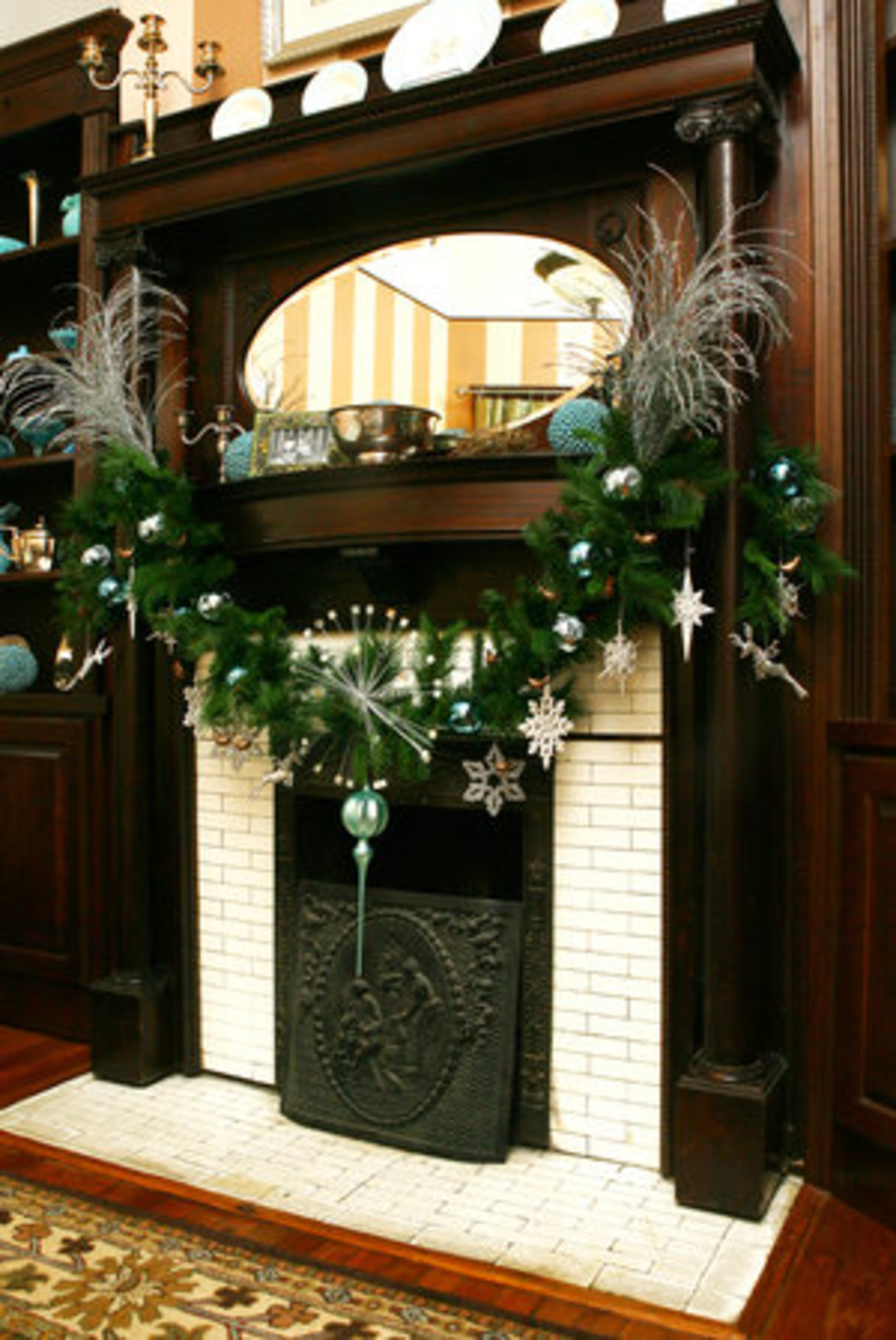Evergreen hung with turquoise and silver ornaments as well as snowflakes decorates the parlor mantle.