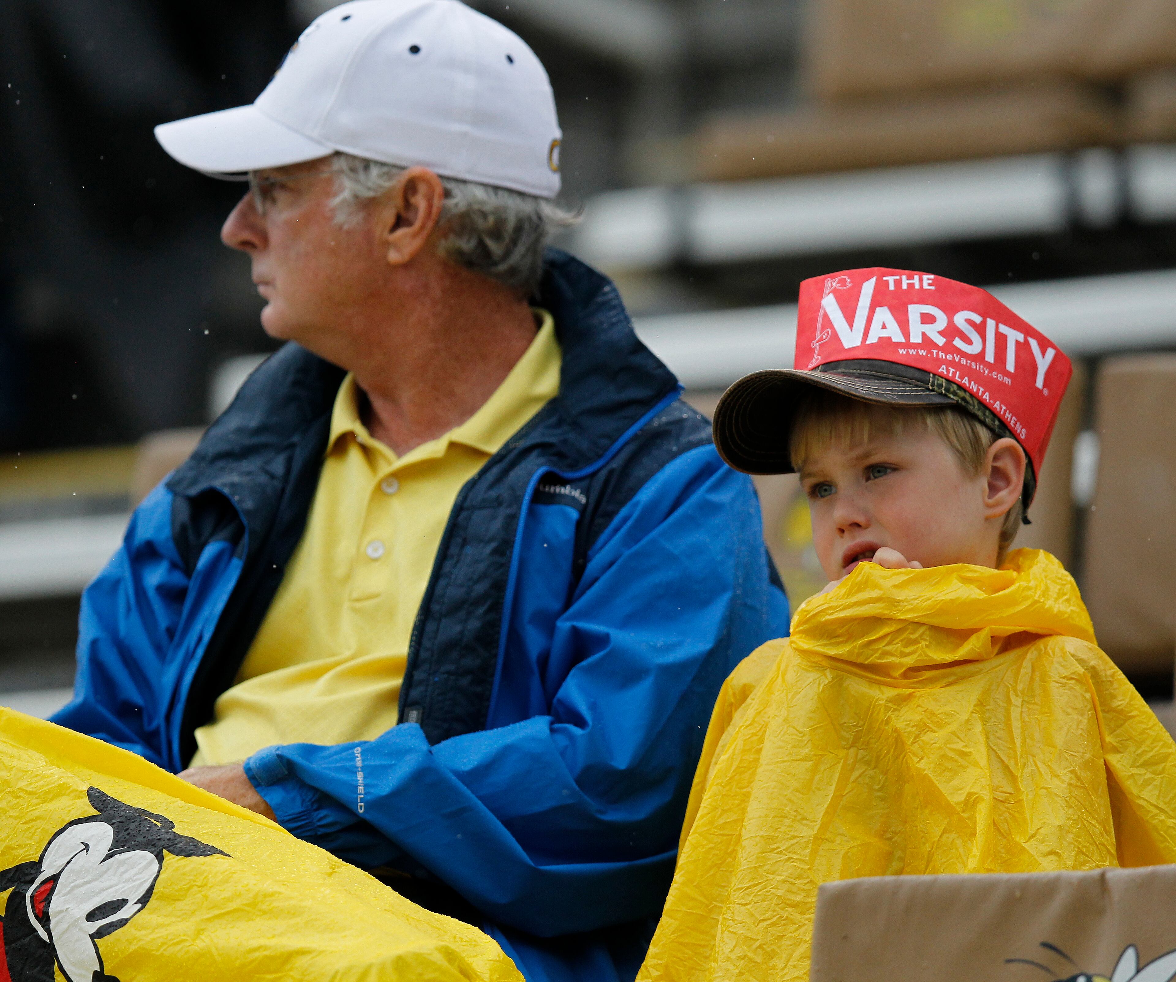 Georgia Tech fans try to stay dry as they watch players warm up.