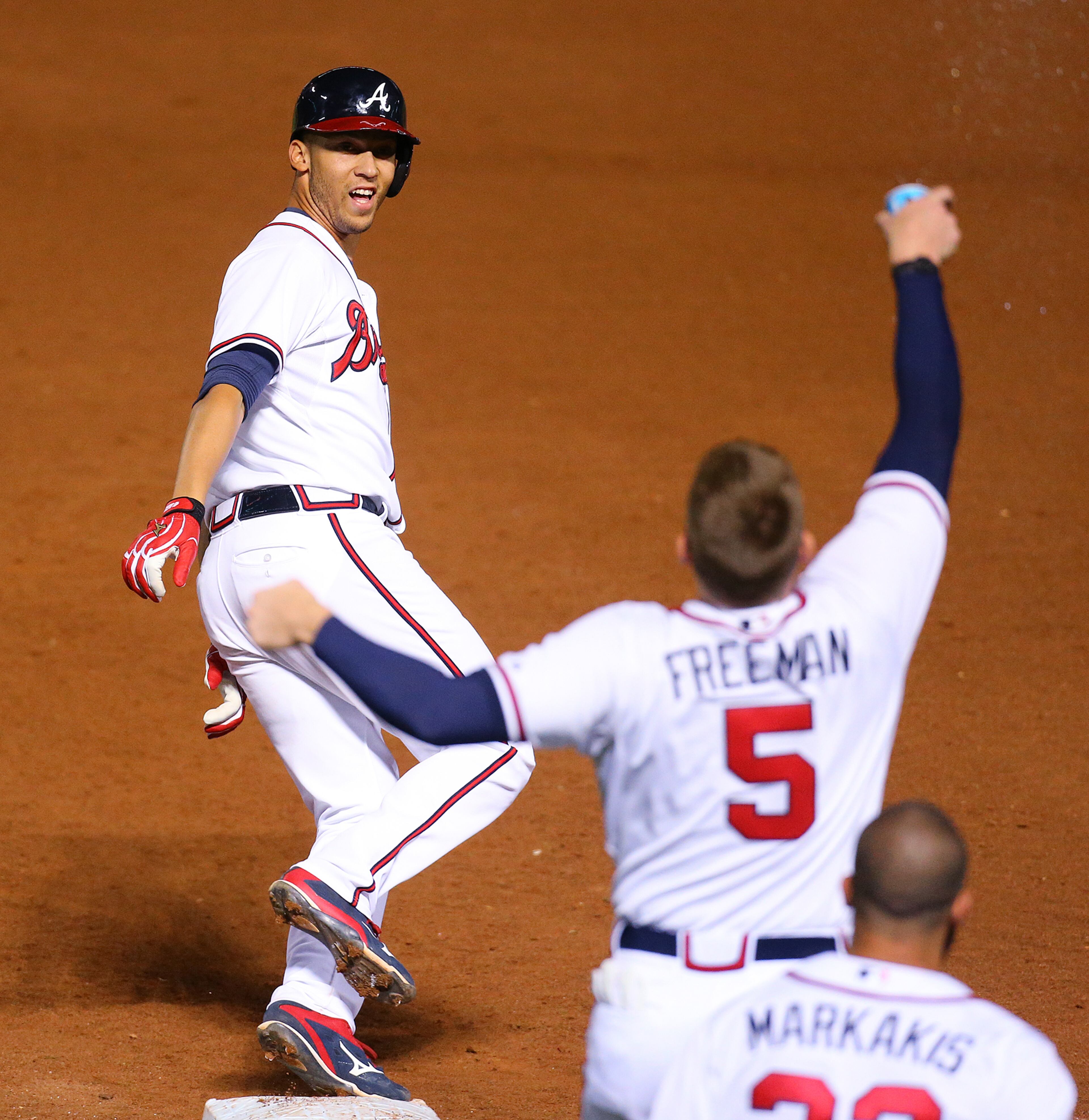 Braves Andrelton Simmons is chased by Freddie Freeman as he rounds first hitting a walk off game winning RBI single to beat the Blue Jays 3-2 in the 9th inning of a baseball game on Tuesday, Sept. 15, 2015, in Atlanta. Curtis Compton / ccompton@ajc.com