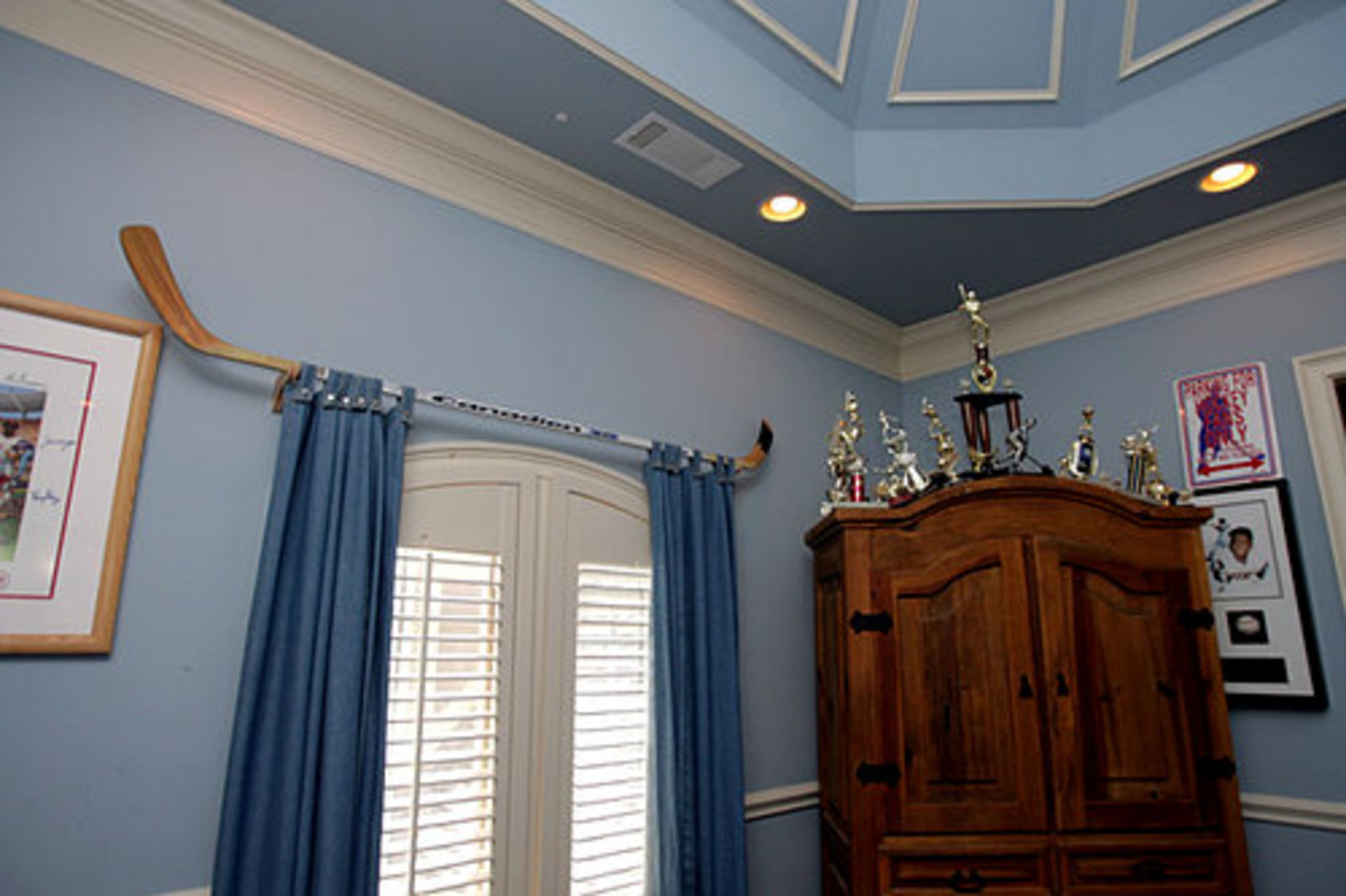 A curtain rod made from a hockey stick sets the tone in the boys' bedroom.