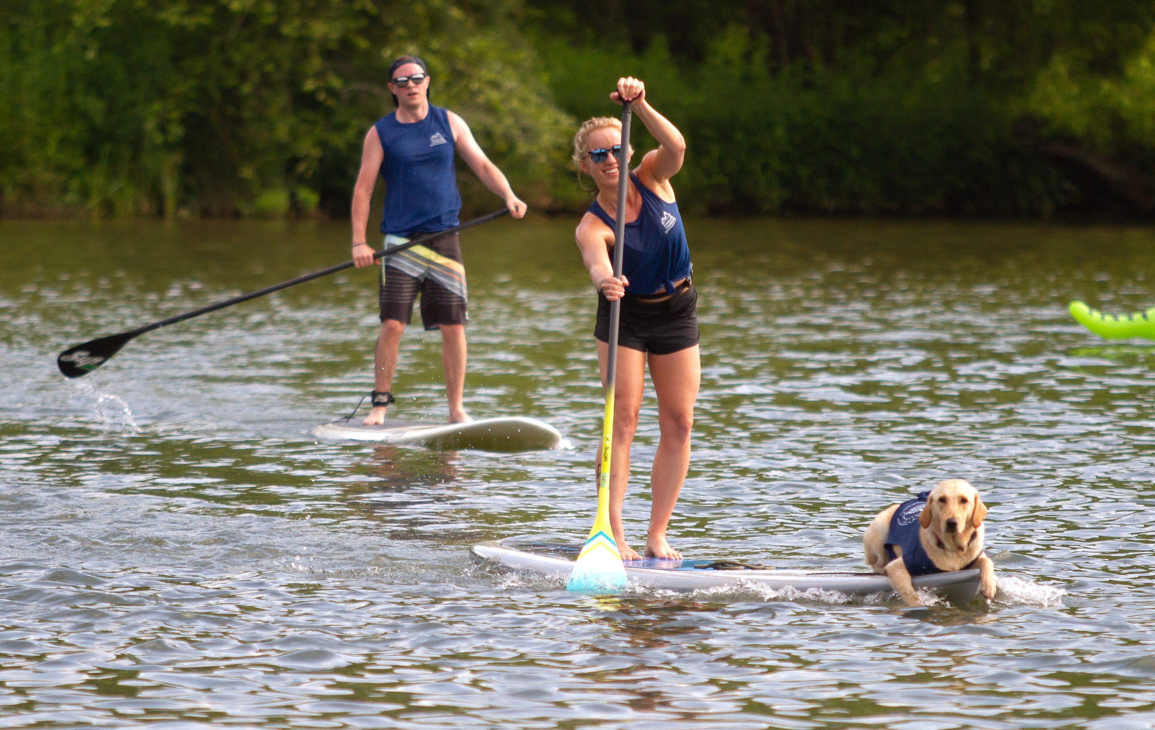 Caroline Slone, crosses the finish line with her dog Burkley during the 8th annual Stand Up for the Hooch at Morgan Falls Overlook Park in Sandy Springs on Sunday, June 23, 2019. STEVE SCHAEFER / SPECIAL TO THE AJC