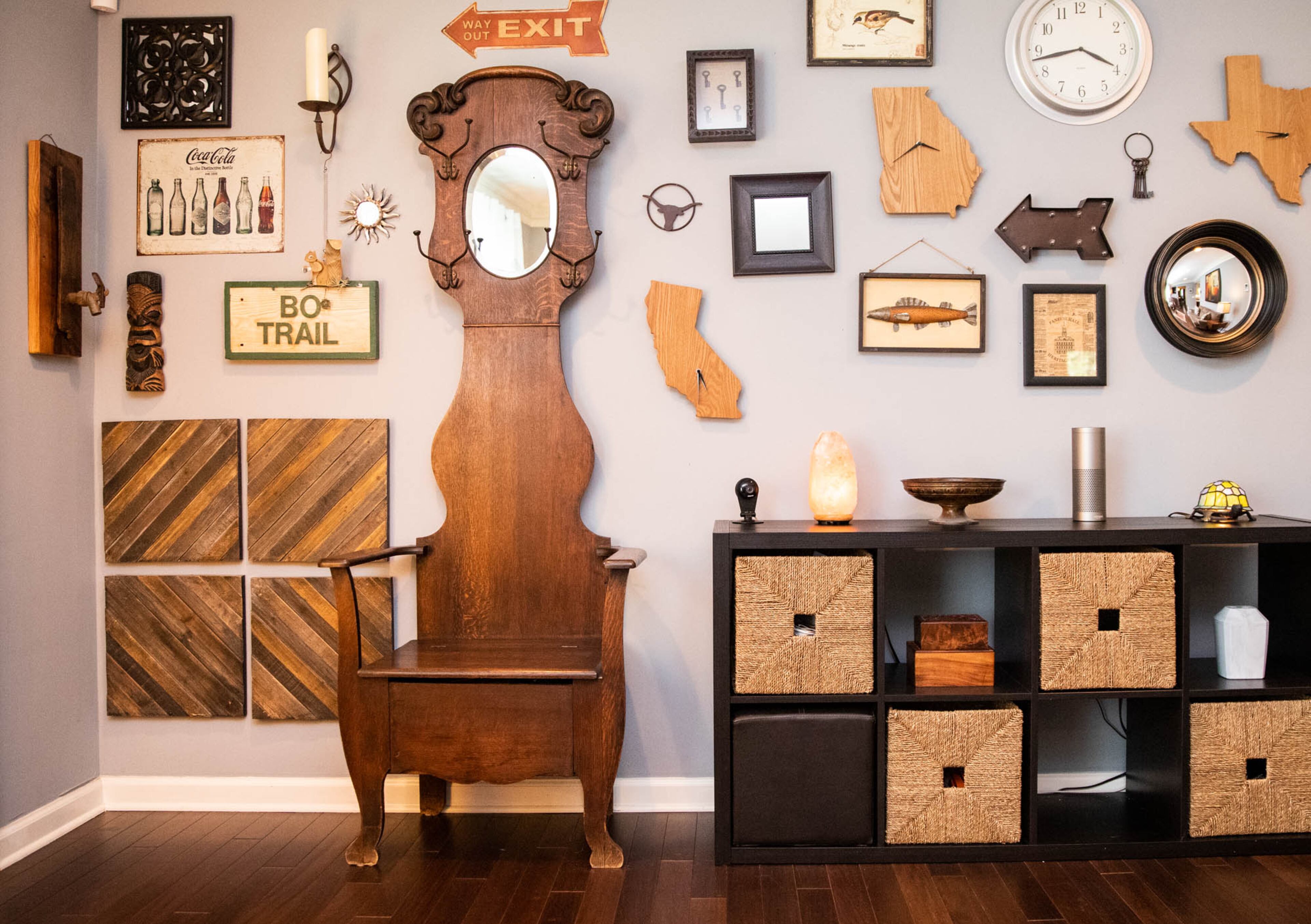 The gallery wall in Adam Perry and Ben Ratossa's entryway is made up of things the couple have collected to represent their lives, like the wooden clocks from Bed Bath & Beyond in the shapes of the three states in which the two have lived together: Georgia, California and Texas. The turtle lamp on the console table, one of several turtles throughout the house, is Ratossa's from when he was a teenager.