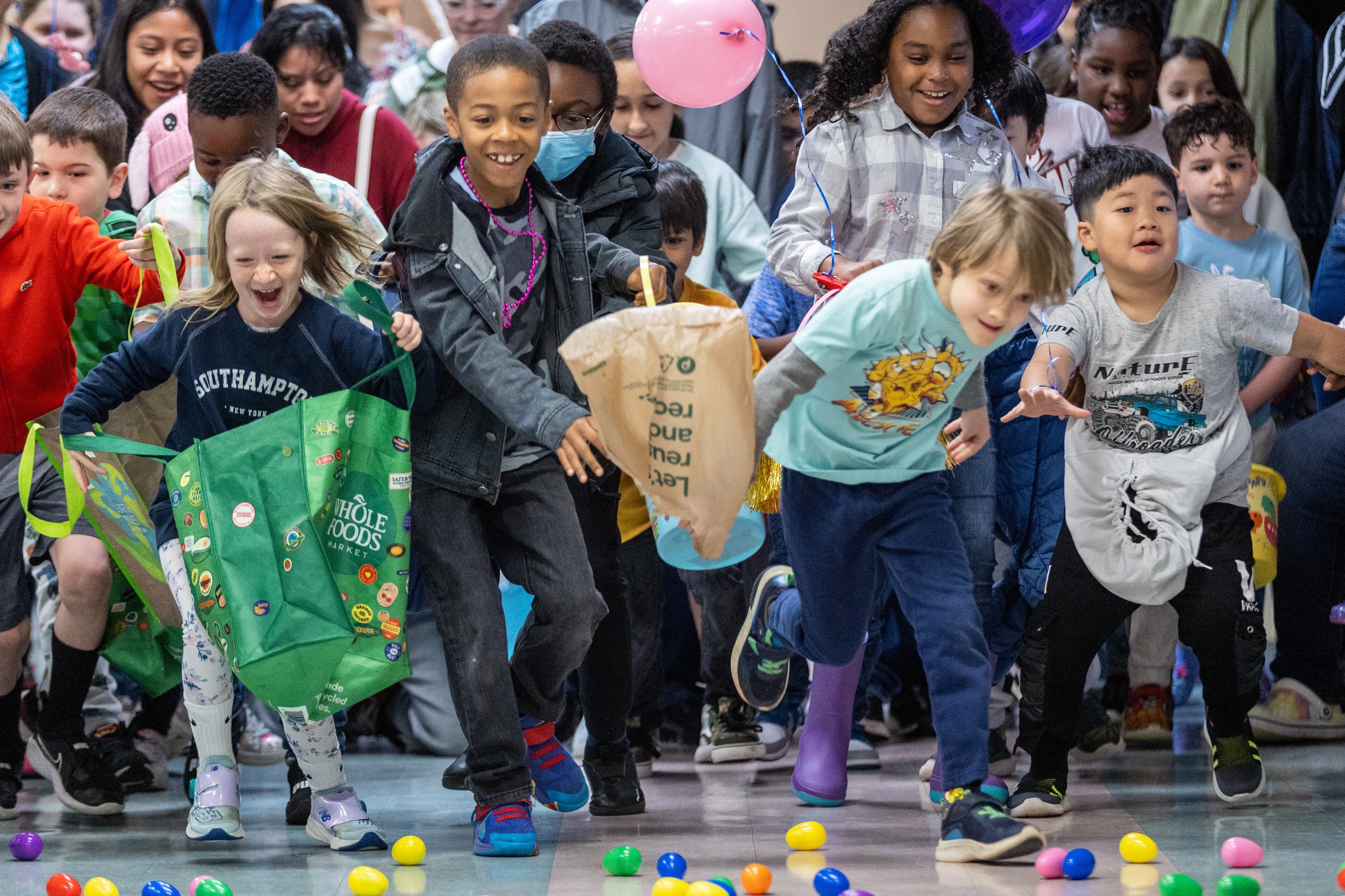 Kids race to gather eggs at the Mason Mill Park and Bridgepoint Church indoor Easter egg hunt Saturday, April 8, 2023. The event was moved inside because of the rain. (Steve Schaefer/steve.schaefer@ajc.com)