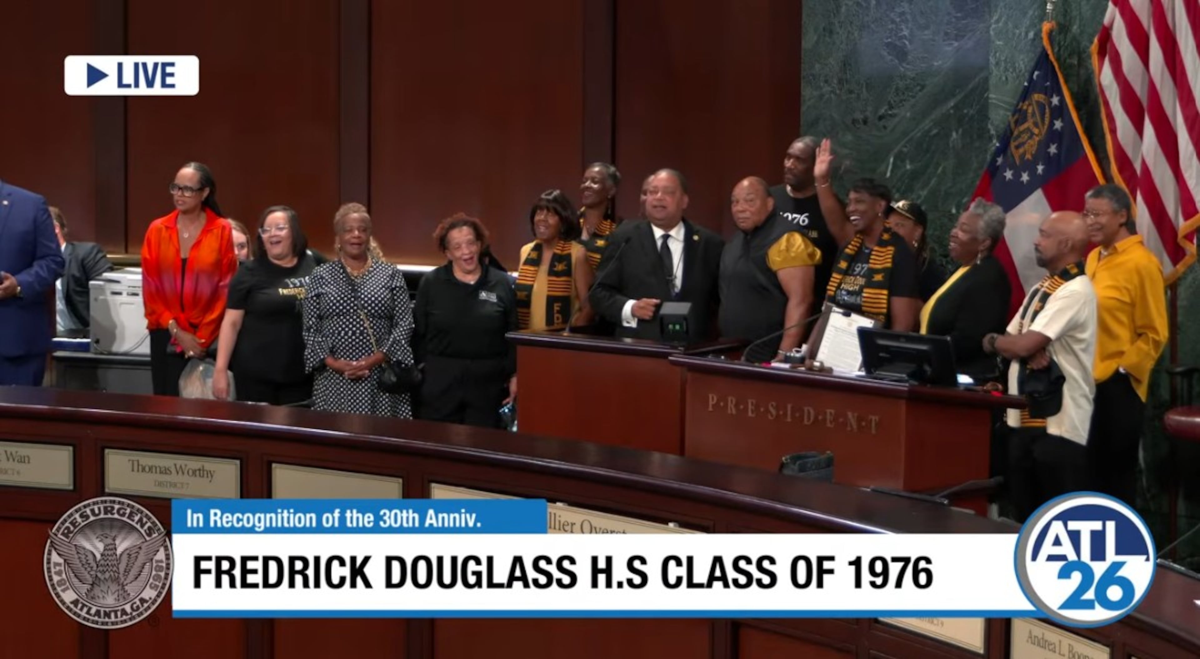 City Council member Michael Julian Bond (center right, in suit) leads Douglass High's Class of 1976 in a rendition of their school's fight song Monday, Aug. 17, 2026, at City Hall. (ATL 26 screenshot)