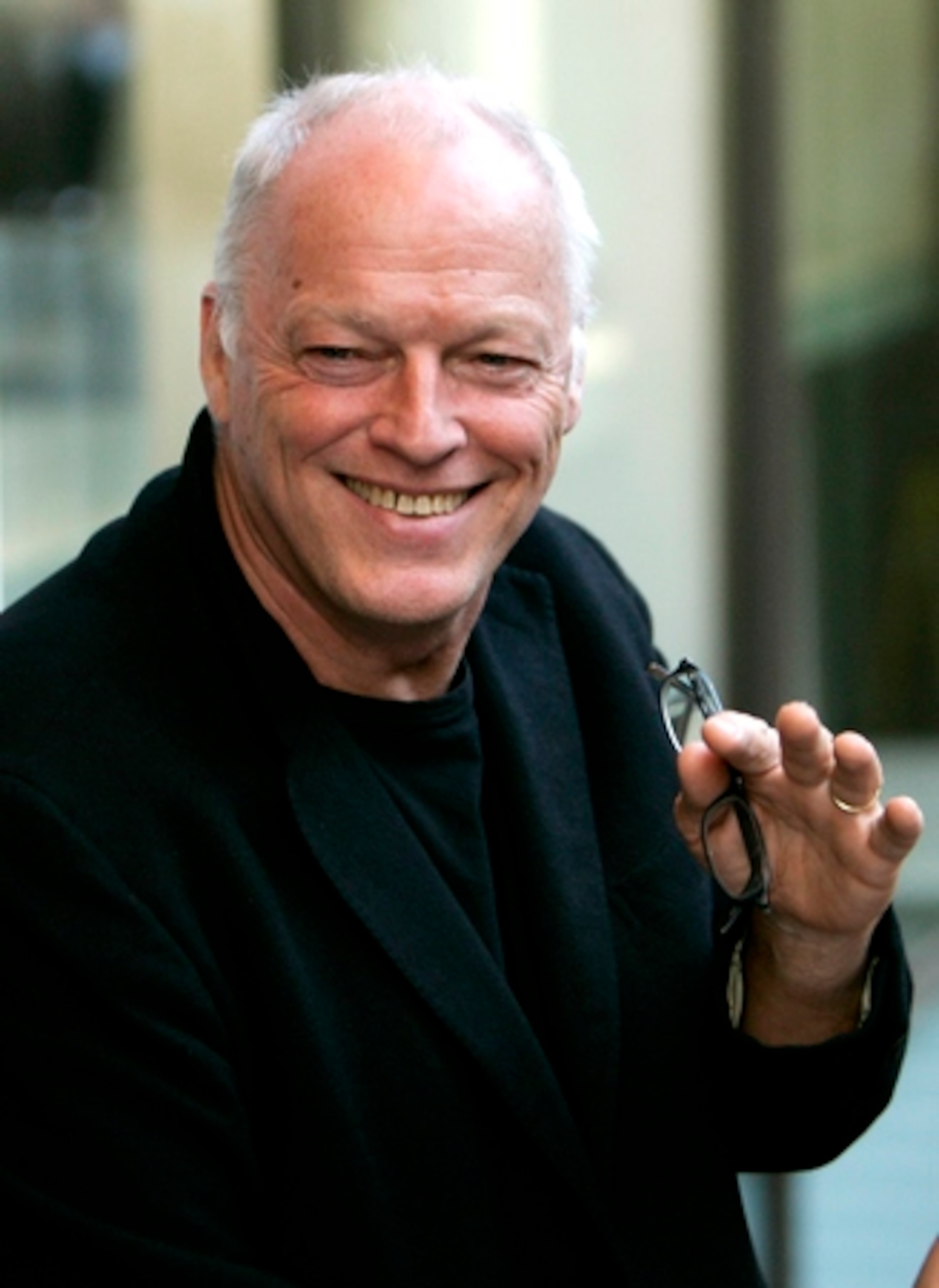 DAVID GILMOUR of Pink Floyd waves to the camera.