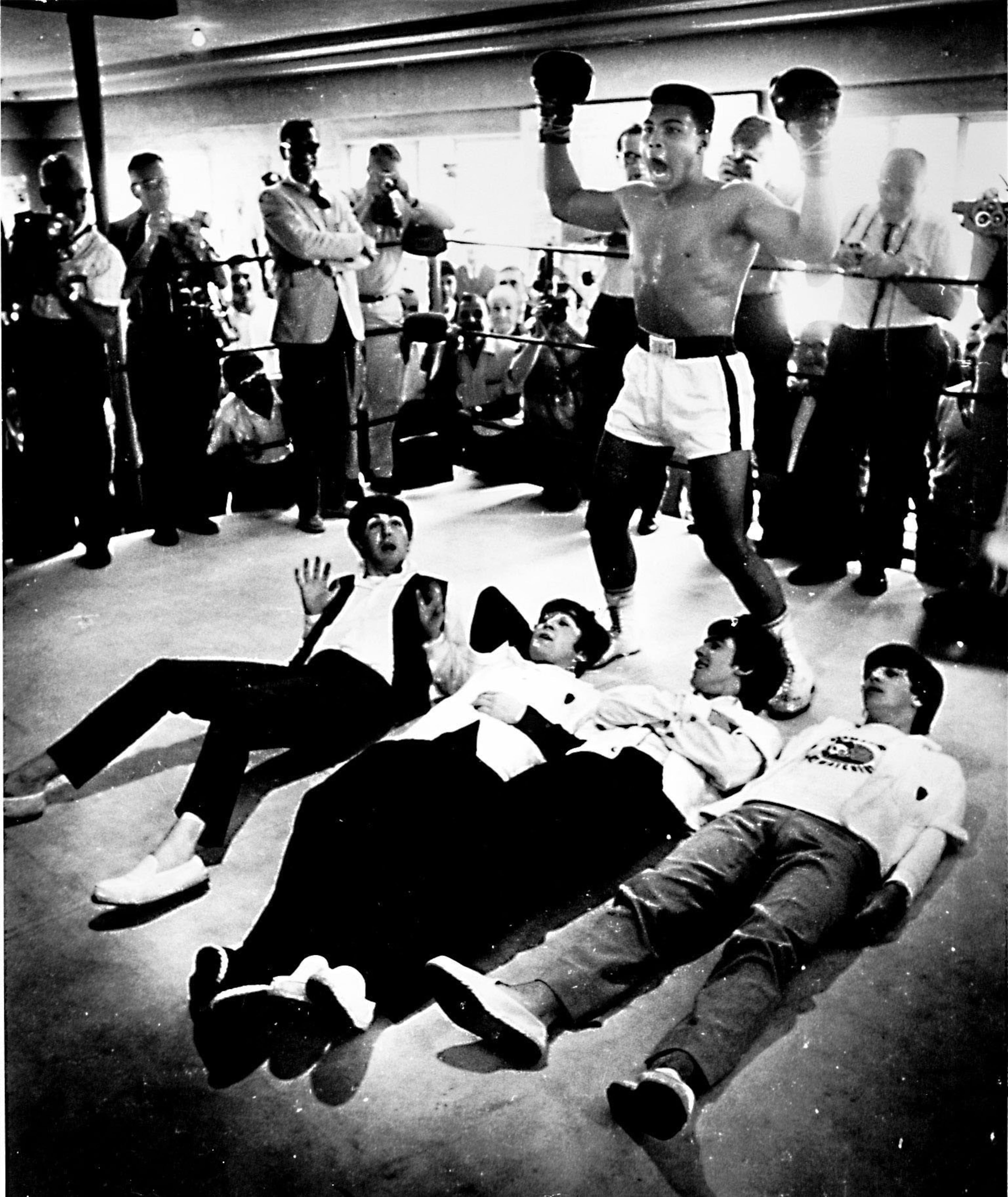 Muhammad Ali "triumphs" over The Beatles, who visited the heavyweight champ at the Fifth Street Gym in Miami Beach, in 1965. (Photo by Charles L. Trainor)