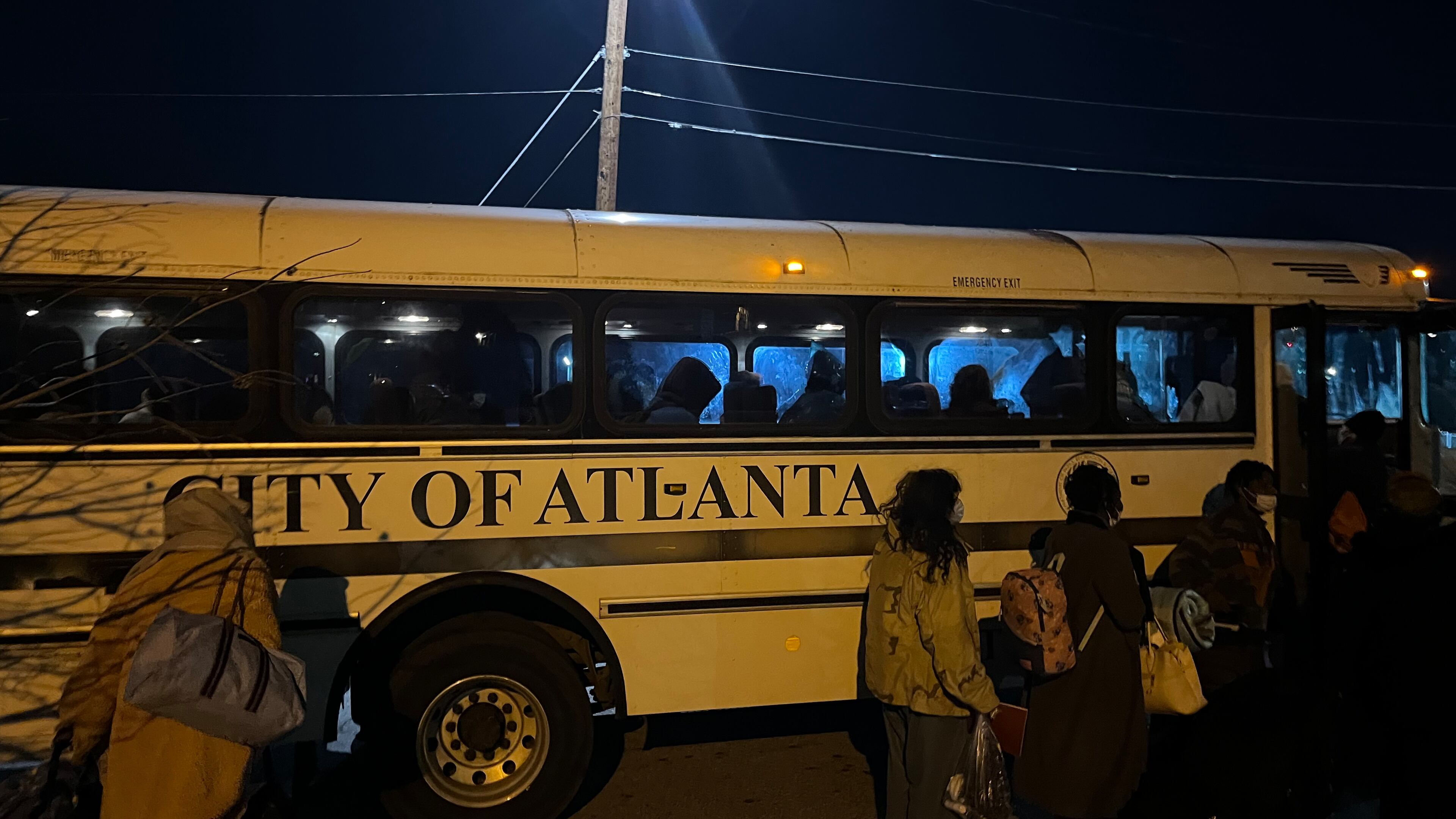 Women and children who were staying in a crowded city of Atlanta warming center at Central Park lined up to take a city bus to an overflow warming center opened nearby on Jan. 16, 2024. The frigid temperatures led more people to see a way out of the cold. Matt Kempner / AJC