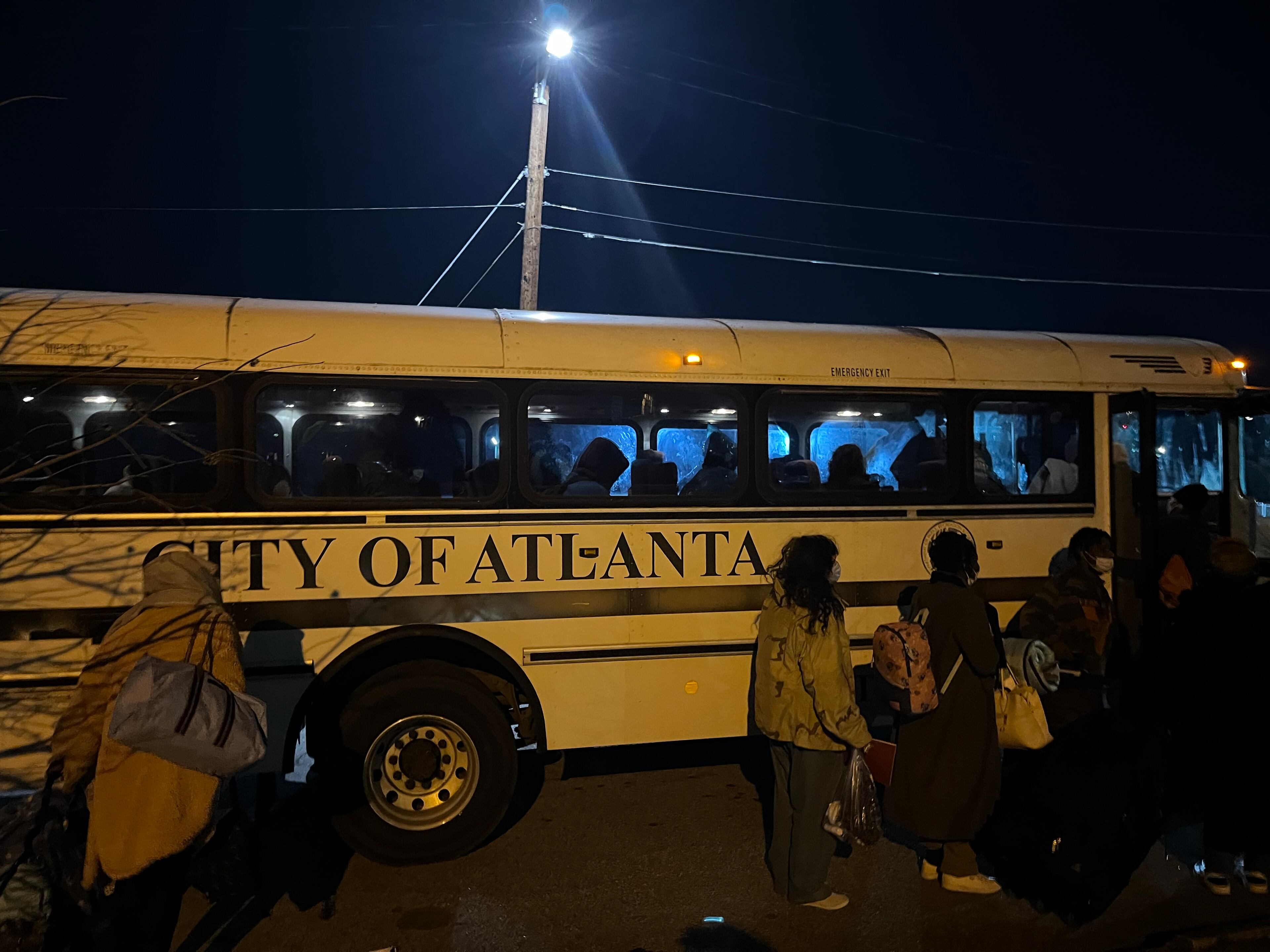 Women and children who were staying in a crowded city of Atlanta warming center at Central Park lined up to take a city bus to an overflow warming center opened nearby on January 16, 2024. The frigid temperatures led more people to seek a way out of the cold. Matt Kempner / AJC
