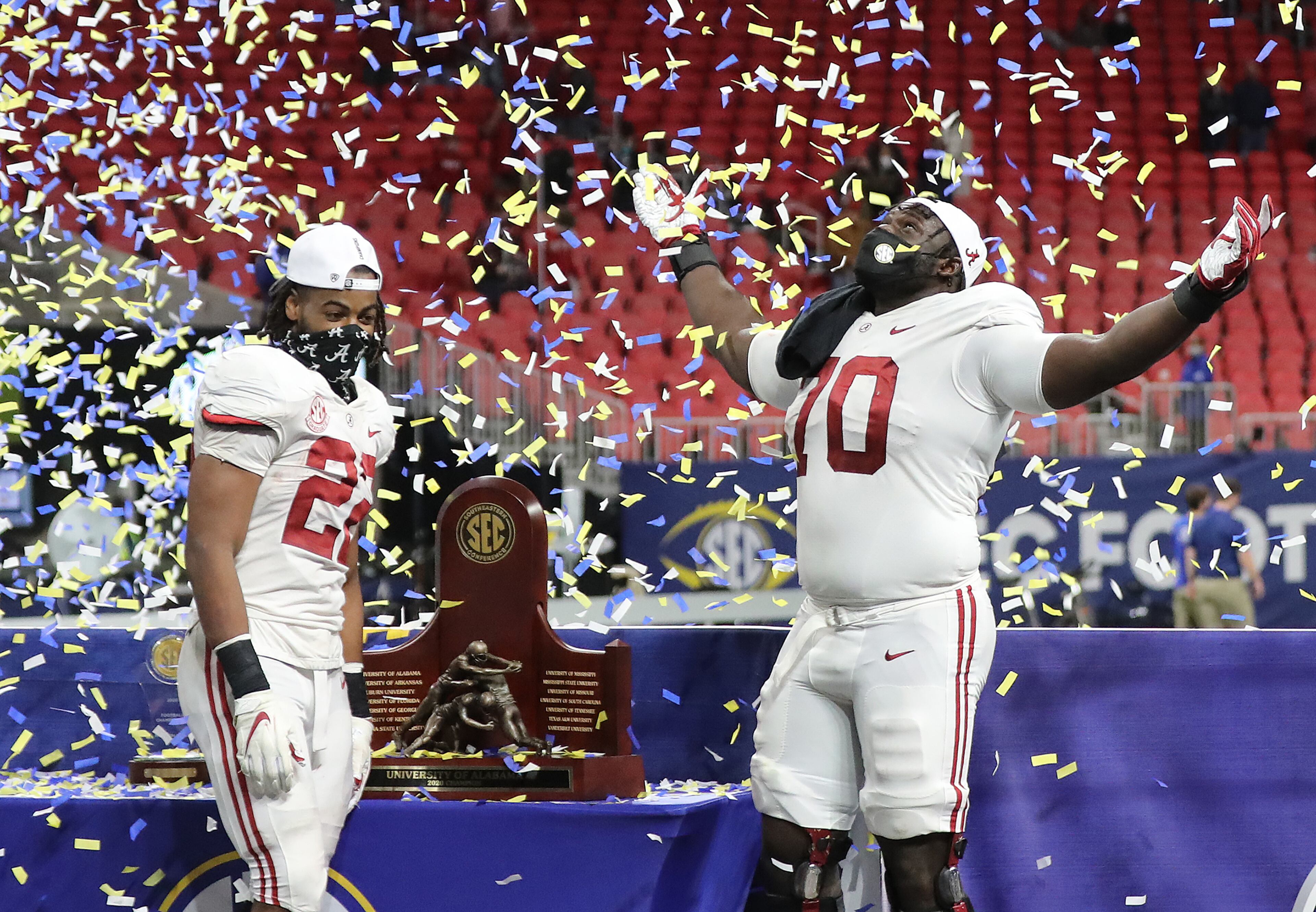 Alabama MVP running back Najee Harris (left) and defensive lineman Alex Leatherwood celebrating a 52-46 victory over Florida in the SEC Championship NCAA college football game on Saturday, Dec. 19, 2020, in Atlanta. “Curtis Compton / Curtis.Compton@ajc.com”