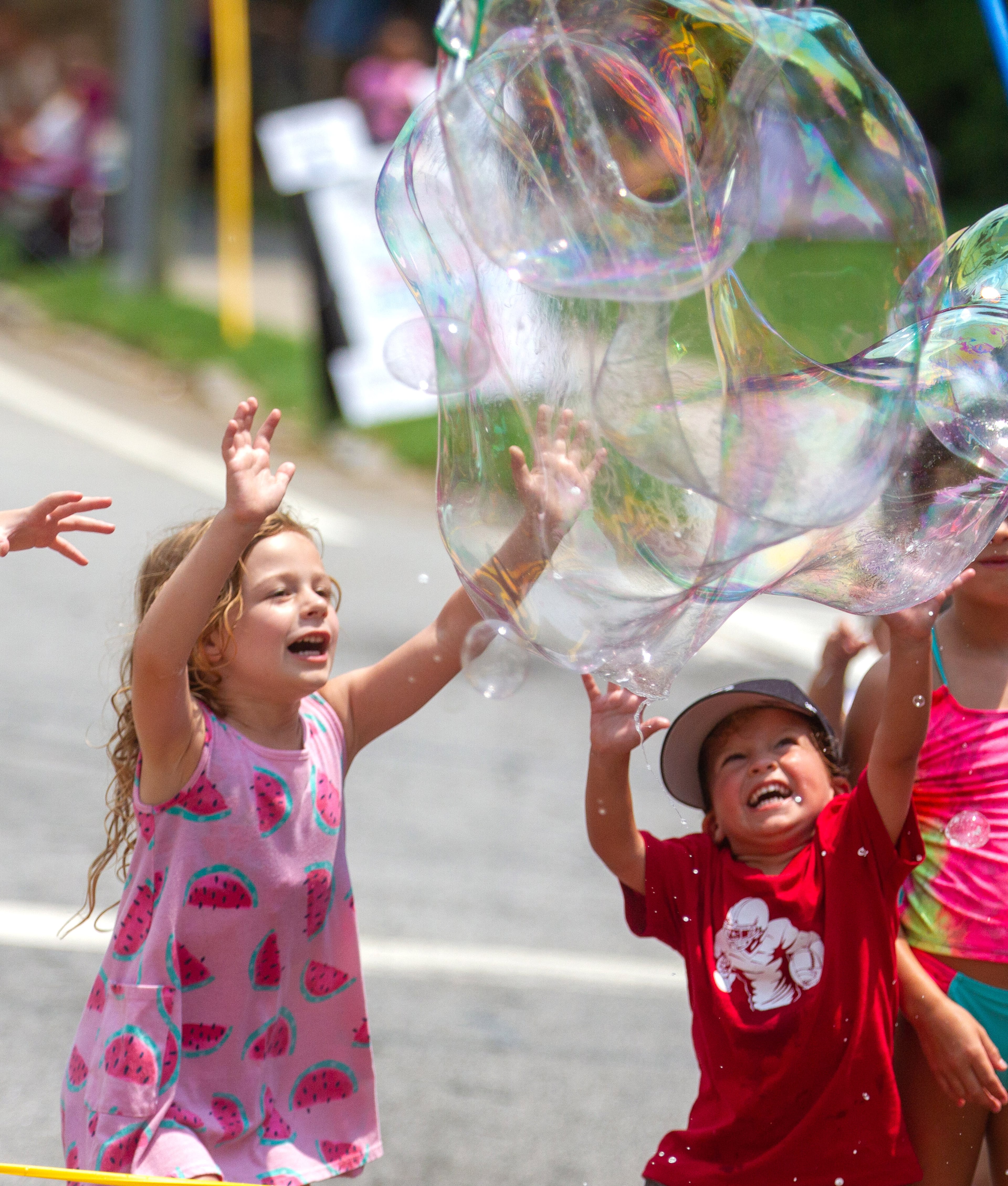 Kids pop large bubbles created by Deborah Mosher during the Brookhaven Cherry Blossom Festival on Saturday, July 31, 2021. STEVE SCHAEFER FOR THE ATLANTA JOURNAL-CONSTITUTION