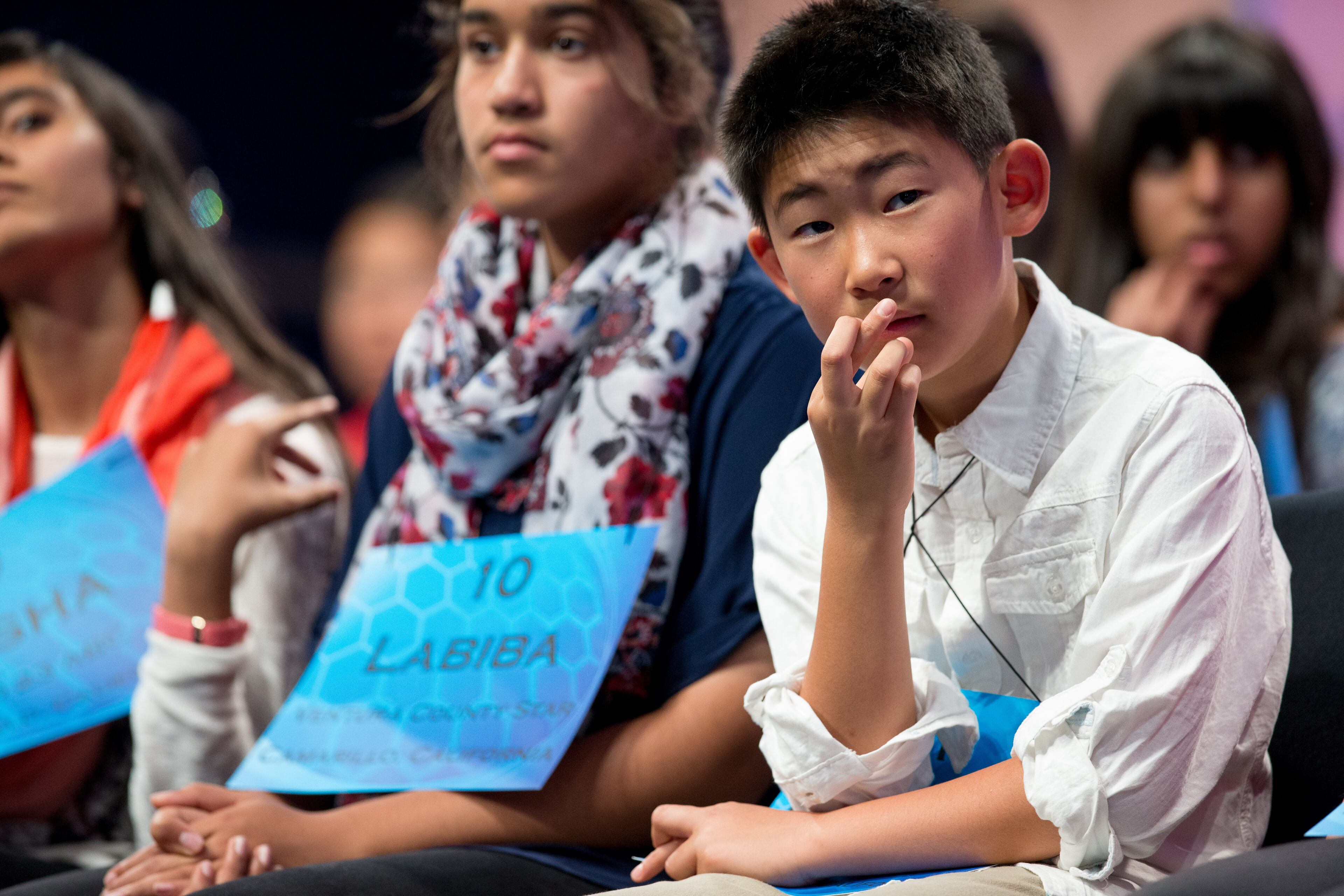 Nicholas Lee, 11, of Diamond Bar, Calif., right, crosses his fingers as he and others listen to a speller during the 2015 Scripps National Spelling Bee, Wednesday, May 27, 2015, in Oxon Hill, Md. (AP Photo/Andrew Harnik)