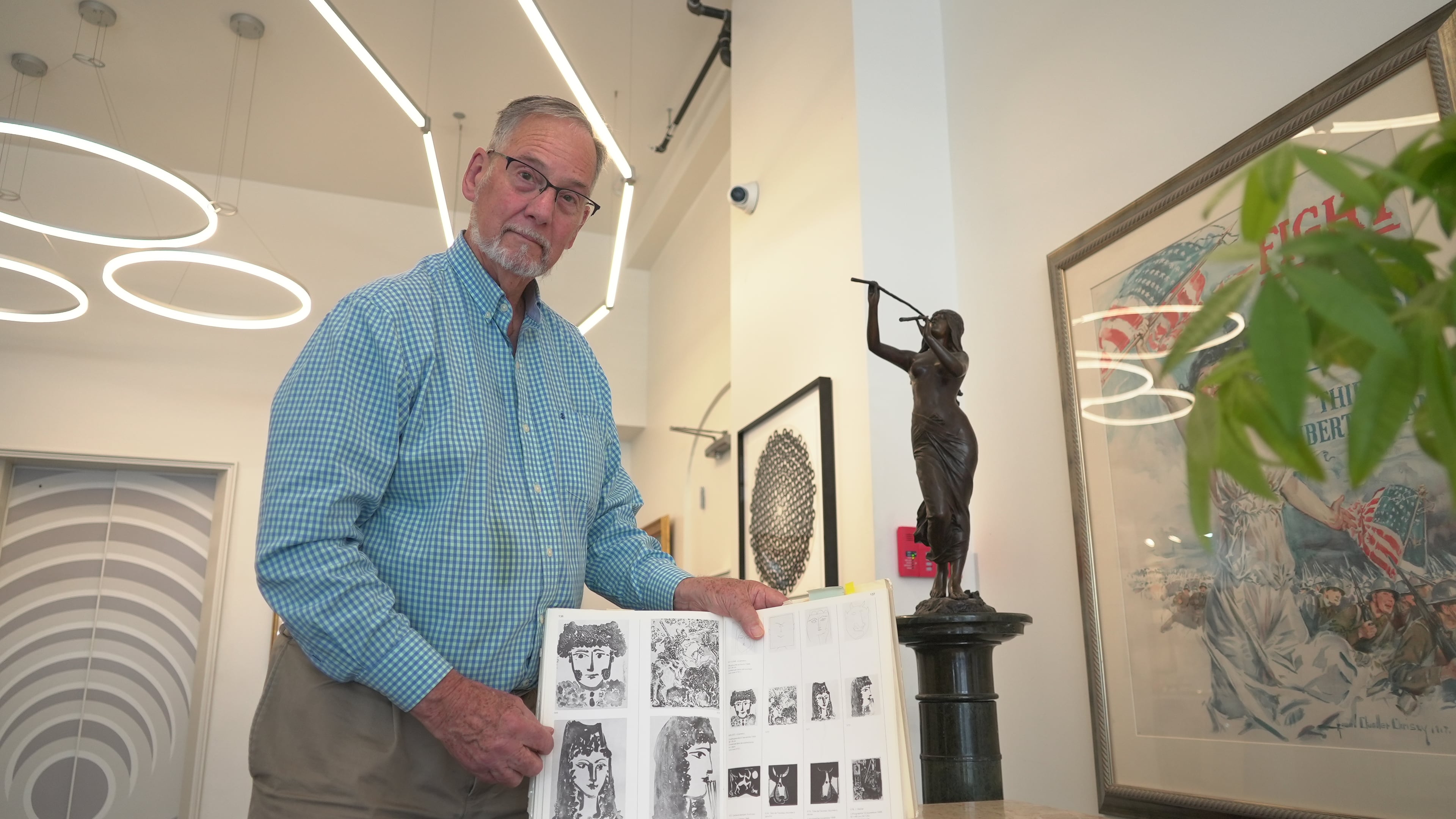 Art dealer Bill DeLind shows a picture of a Pablo Picasso sketch (upper left) stolen from his shop DeLind Fine Art Appraisals in 2018 in Milwaukee on Aug. 14, 2026. The sketch was recently found in town. (AP Photo/Laura Bargfeld)