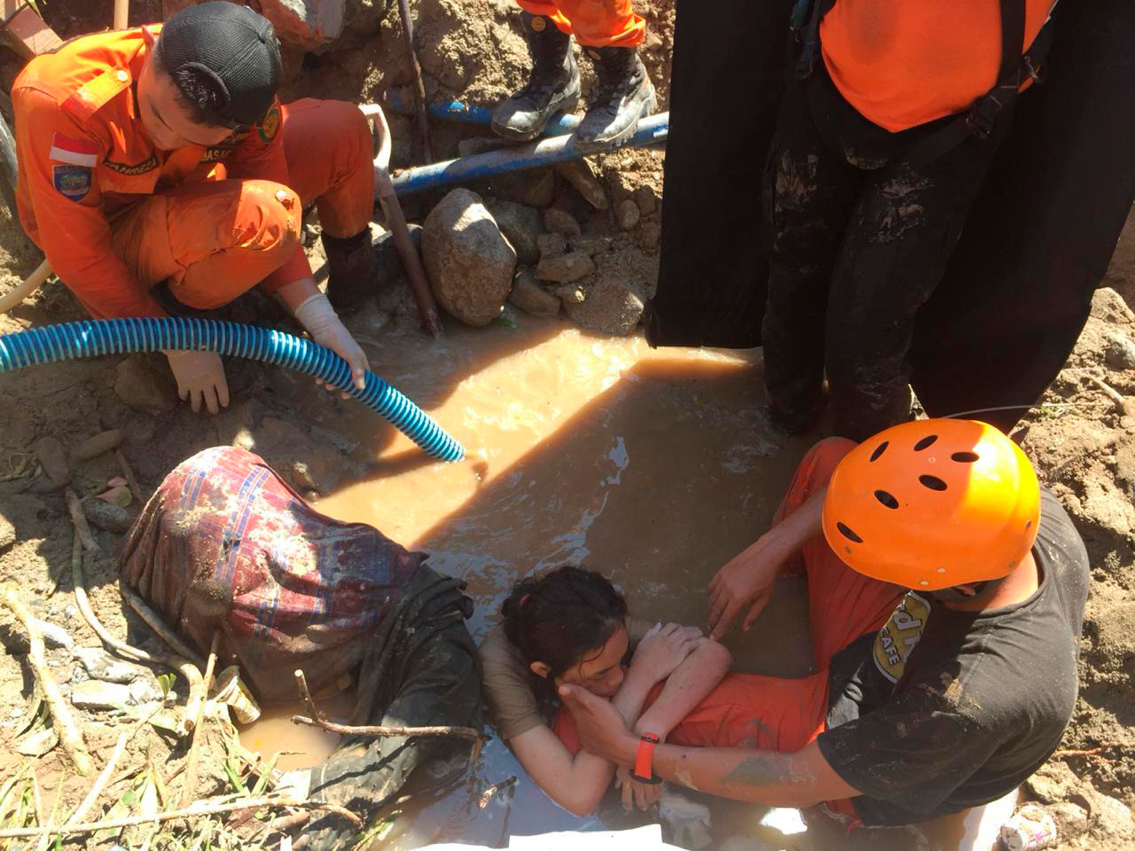 Indonesia rescue team evacuate a women from damage following earthquakes and a tsunami in Palu, Central Sulawesi, Indonesia, Sunday, Sept. 30, 2018. A tsunami swept away buildings and killed large number of people on the Indonesian island of Sulawesi, dumping victims caught in its relentless path across a devastated landscape that rescuers were struggling to reach Saturday, hindered by damaged roads and broken communications. (AP Photo/Chandra)