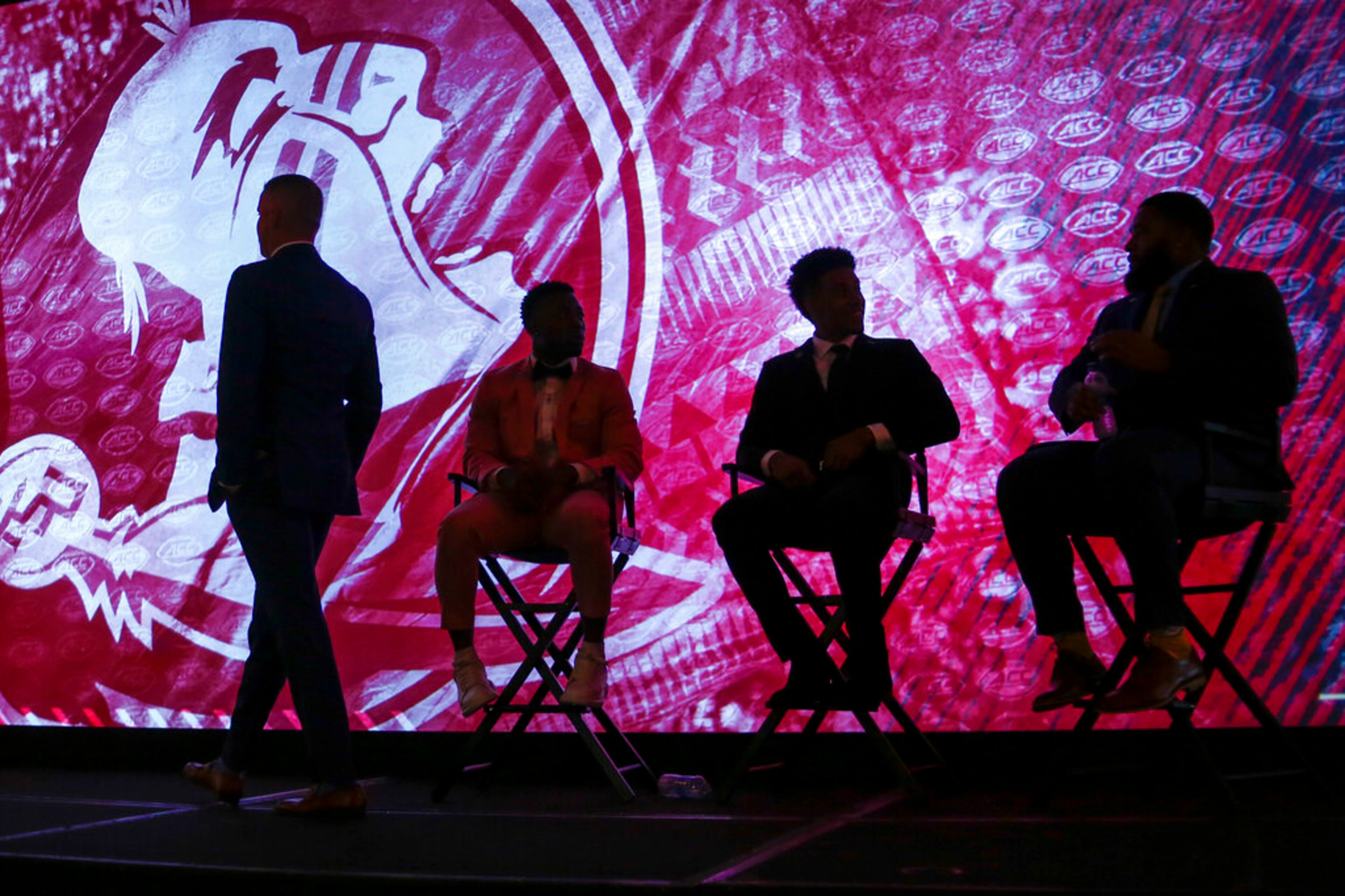 Florida State head coach Mike Norvell, left, walks to the podium as his players sit on the stage at the NCAA college football Atlantic Coast Conference Media Days in Charlotte, N.C., Wednesday, July 20, 2022. (AP Photo/Nell Redmond)