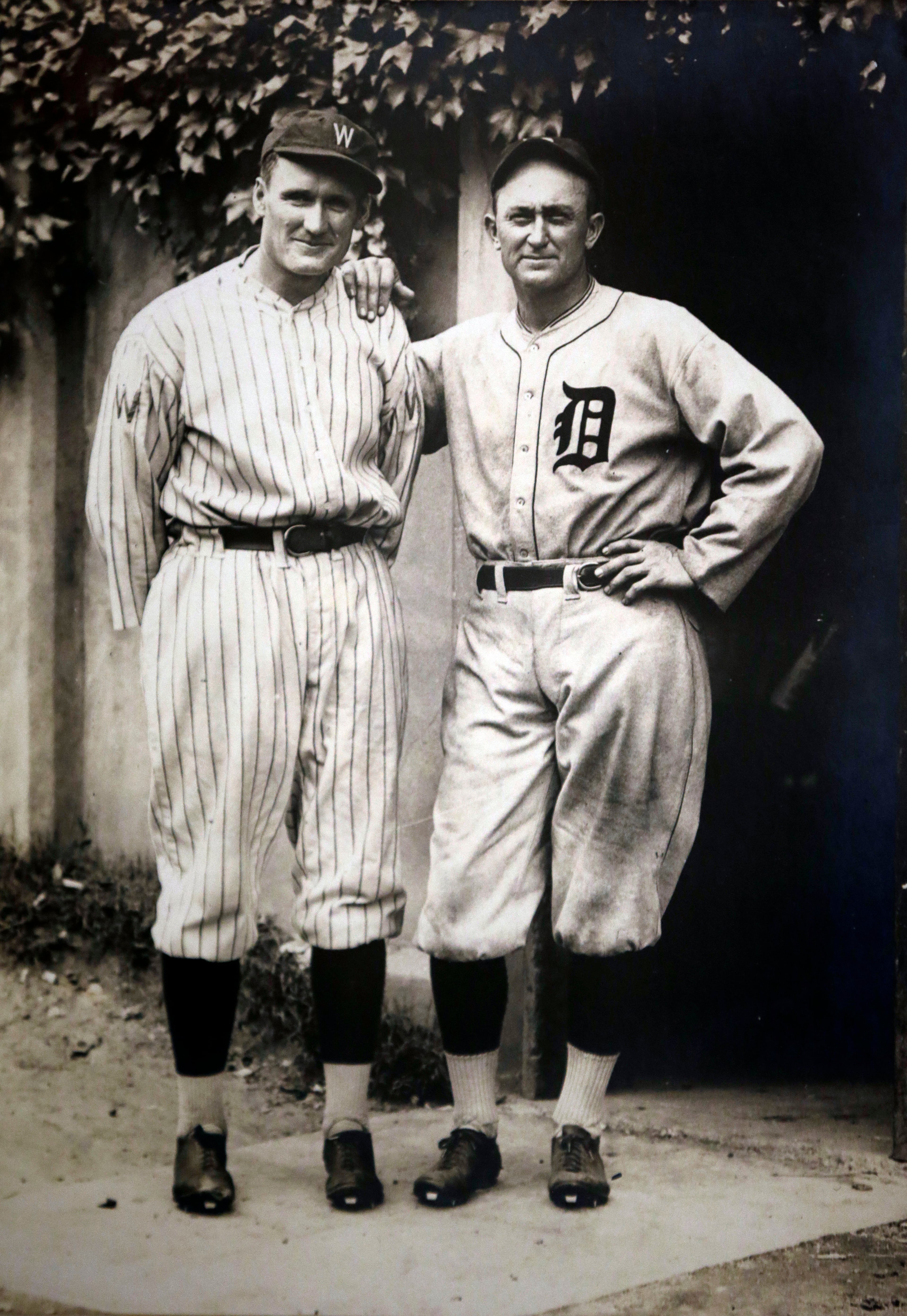 This photo taken Feb. 15, 2013 shows a copy of a 1925 photograph of Washington Senators Walter Johnson, left, and Detroit Tigers Ty Cobb, right, that hangs in the wall of Carolyn Thomas, Johnson's daughter, in her home in Washington. The family is auctioning items including the personalized framed copy of Johnson's plaque from his Hall of Fame induction, a handwritten congratulatory letter from Ty Cobb, the "Notice to Player of Release or Transfer" signed by Senators owner Clark Griffith after Johnson's final season in 1927, and an engraved six-piece tea set celebrating the 20th anniversary of Johnson's signing with the team next weekend. (AP Photo/Pablo Martinez Monsivais)