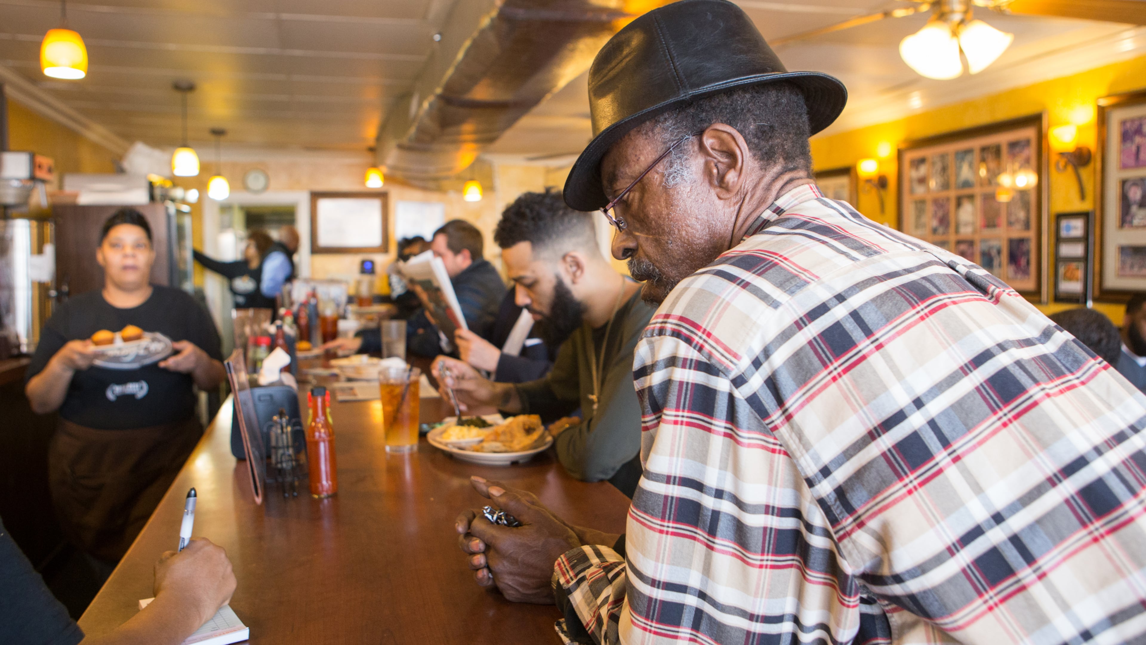 Johnny Scott, a regular at the Busy Bee Cafe, orders oxtails to go at the restaurant on Martin Luther King Jr. Drive in Atlanta in January 2020. The historic soul food restaurant, which opened in 1947, is opening new locations the next two years. (Jenni Girtman for the AJC)