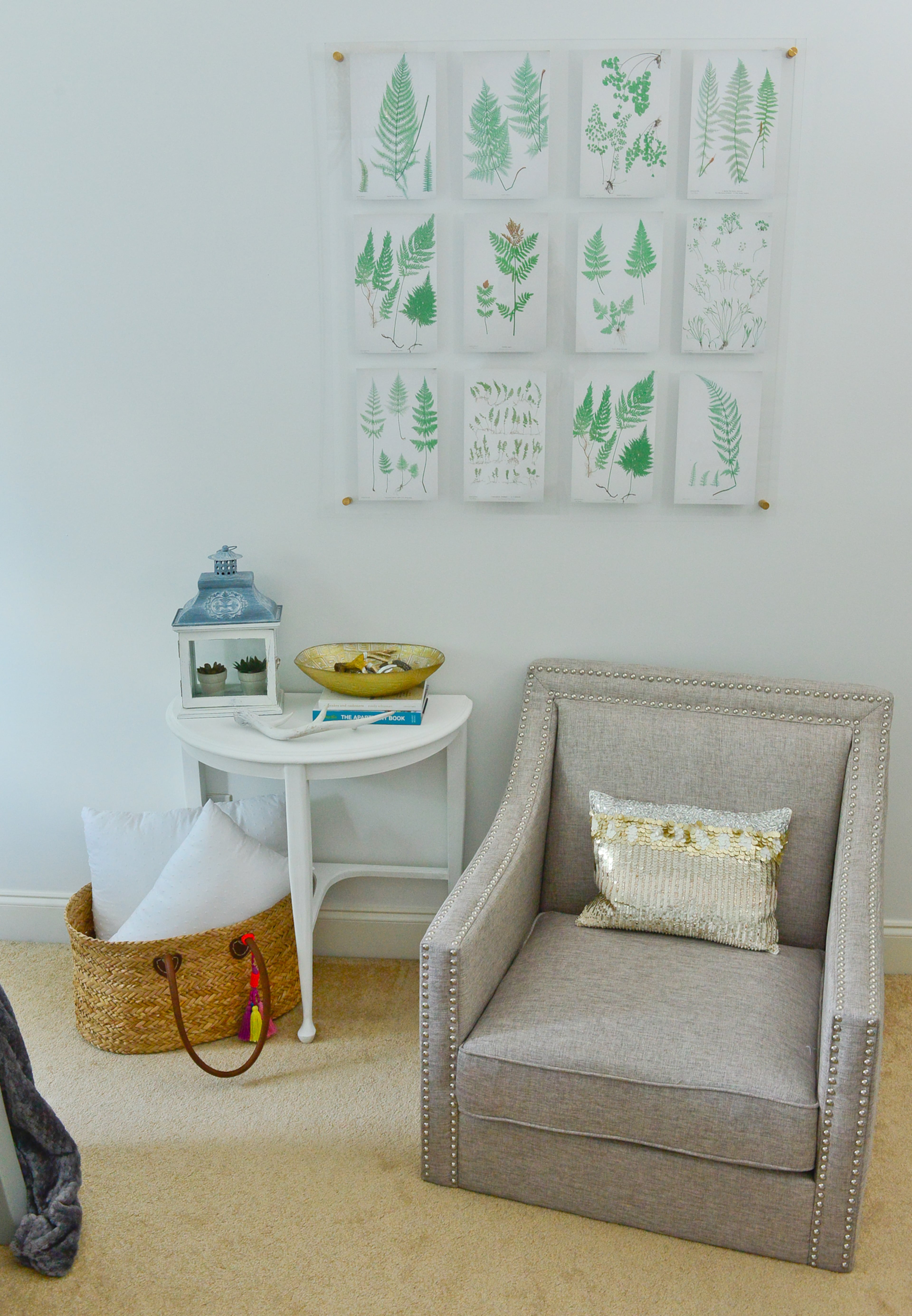 The botanical art is actually a set of free printables from emilyaclark.com, set in a Highland Hardware acrylic frame with gold hardware. The gray upholstered chair was sent to homeowner Yuni Min from Lamps Plus when she participated in the One Room Challenge, a blogger competition.
