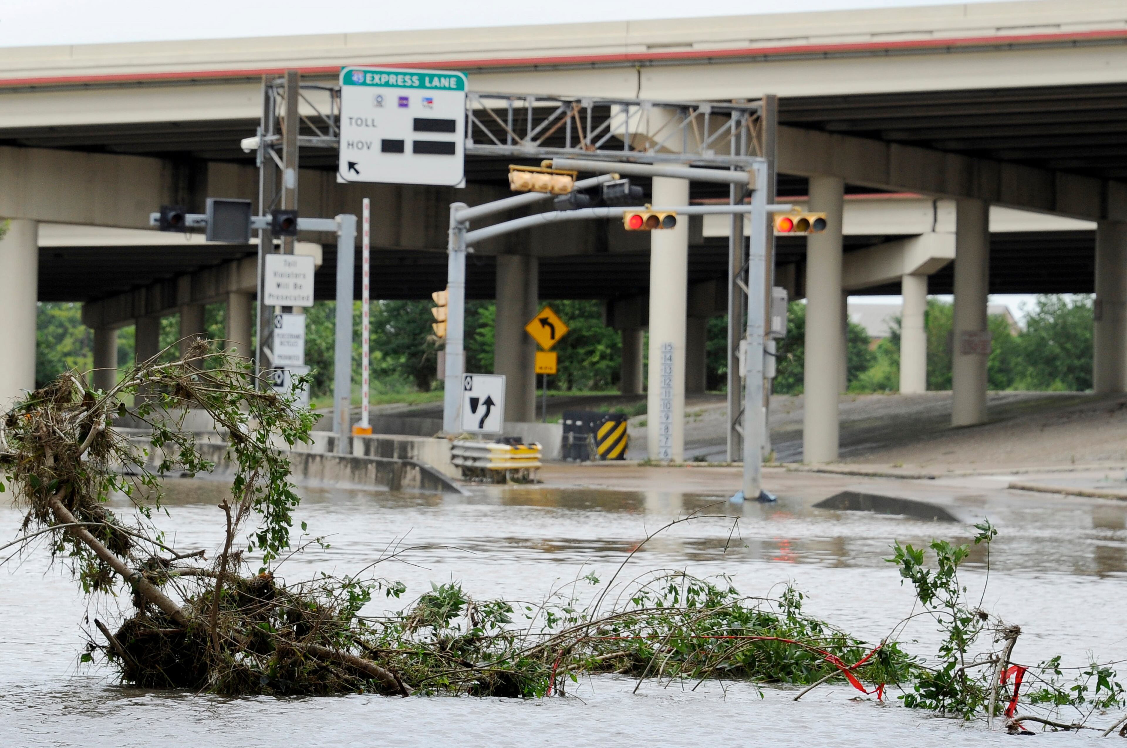 A highway entrance is covered in water and debris after flood waters overran the banks of the bayou in downtown Houston, Tuesday, May 26, 2015. Floodwaters kept rising Tuesday across much of Texas as storms dumped almost another foot of rain on the Houston area, stranding hundreds of motorists and inundating the famously congested highways that serve the nation's fourth-largest city. (AP Photo/Pat Sullivan)