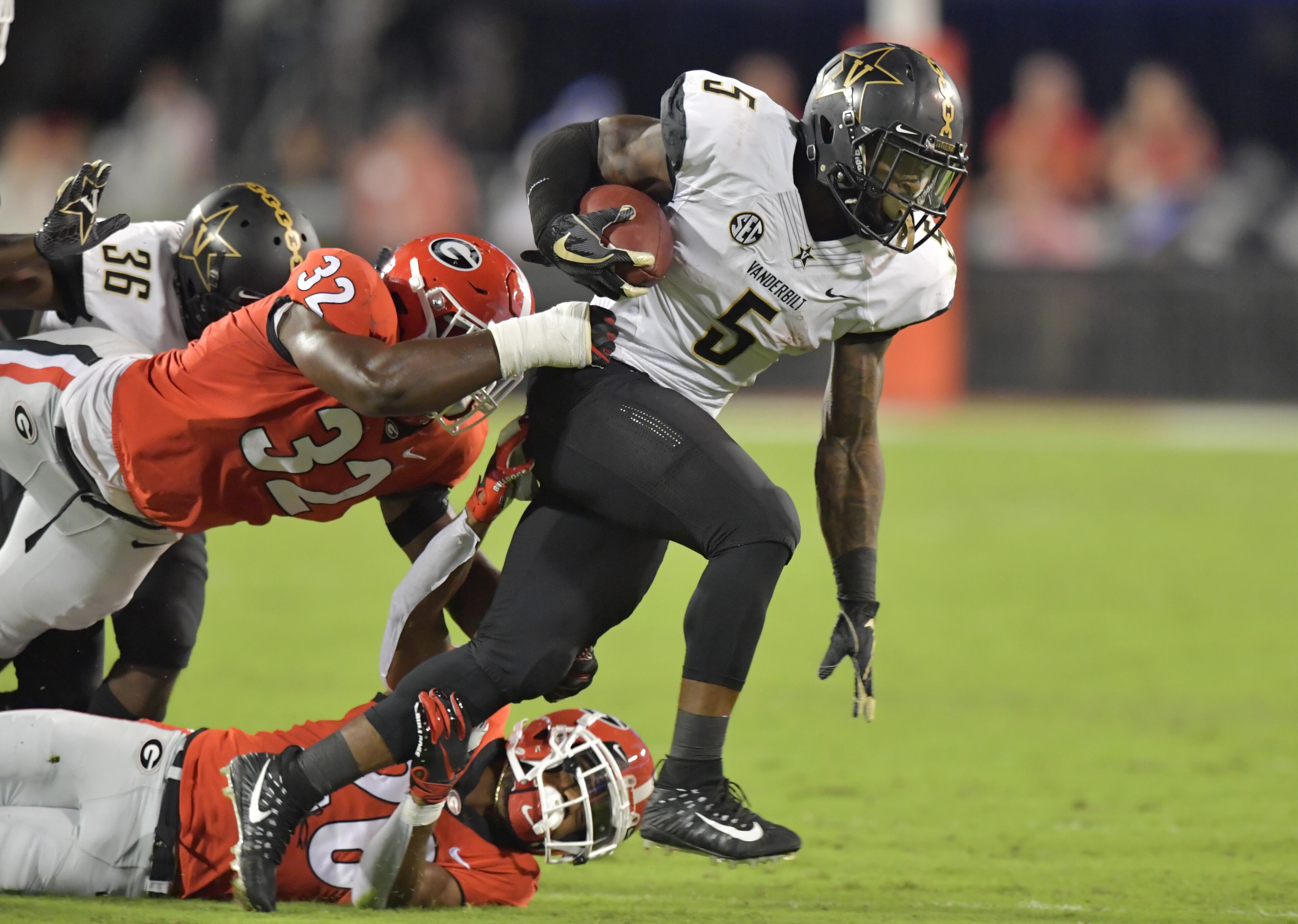 October 6, 2018 Athens - Vanderbilt running back Ke'Shawn Vaughn (5) gets tackled by Georgia linebacker Monty Rice (32) and Georgia defensive back Tyrique McGhee (26) in the first half during a NCAA college football game at Sanford Stadium in Athens on Saturday, October 6, 2018. HYOSUB SHIN / HSHIN@AJC.COM