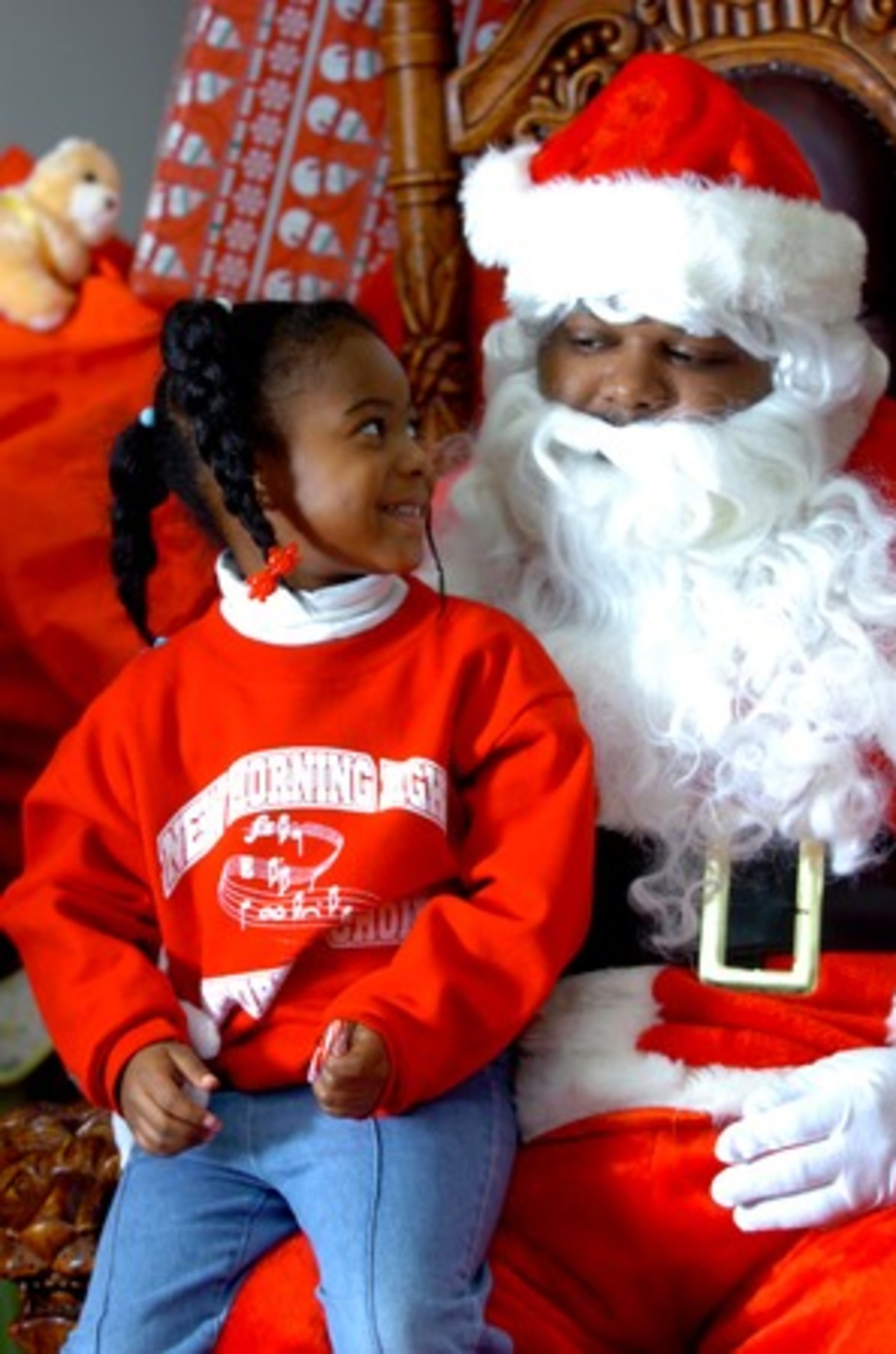 Zuri Webb from New Morning Light Baptist Church, sits on Santa Courtney Dollison's lap at the Ludicrismas party. The event was held Saturday at the Woodruff Arts Center. Children were selected to attend from communities throughout the metro Atlanta area.