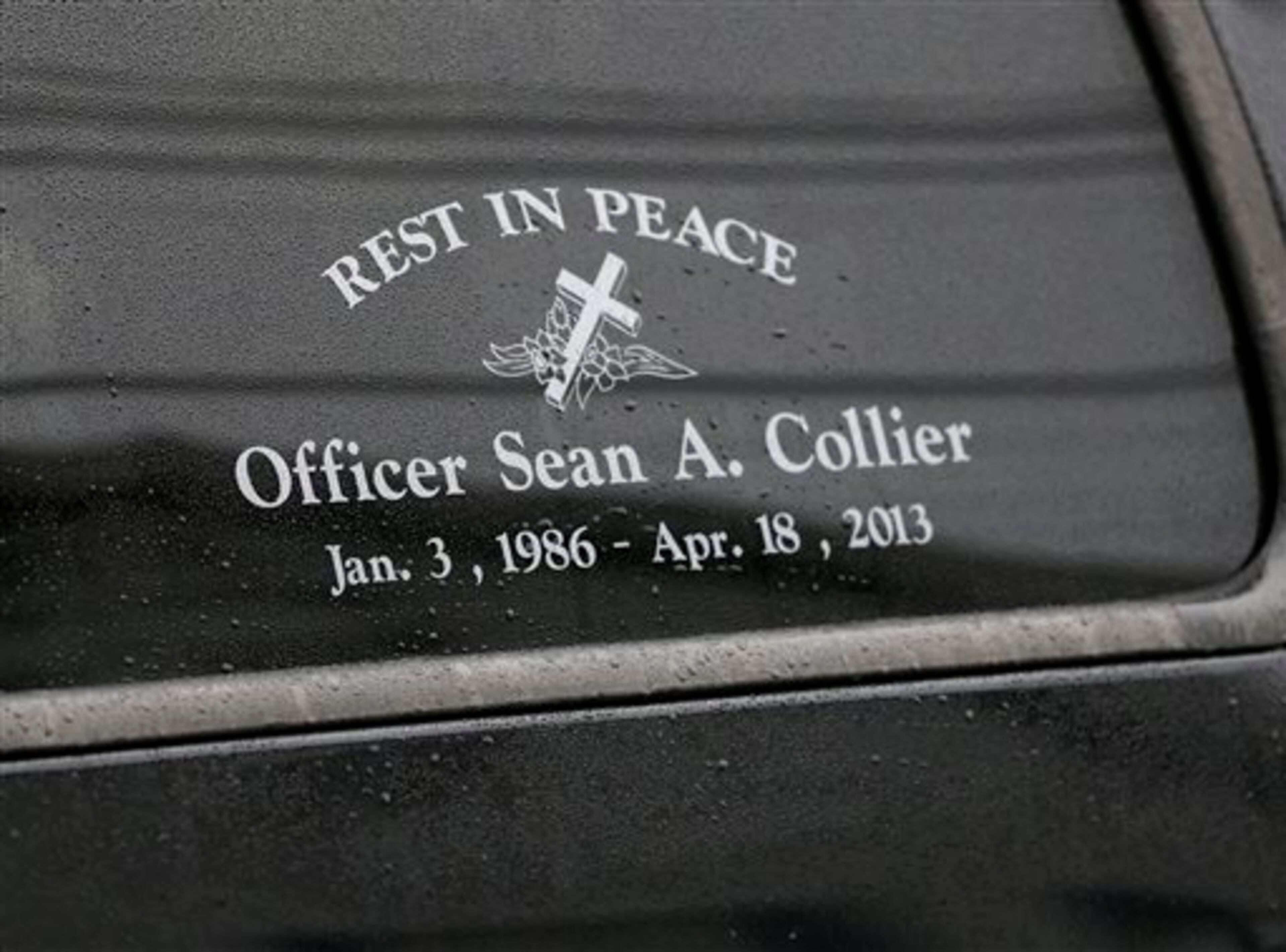 A tribute honoring fallen Massachusetts Institute of Technology police officer Sean Collier is seen on a window of a truck that belonged to Collier as it departs St. Patrick's Church in Stoneham, Mass., following a funeral Mass, Tuesday, April 23, 2013. Collier was fatally shot on the MIT campus Thursday, April 18, 2013. Authorities allege that the Boston Marathon bombing suspects were responsible. (AP Photo/Steven Senne)