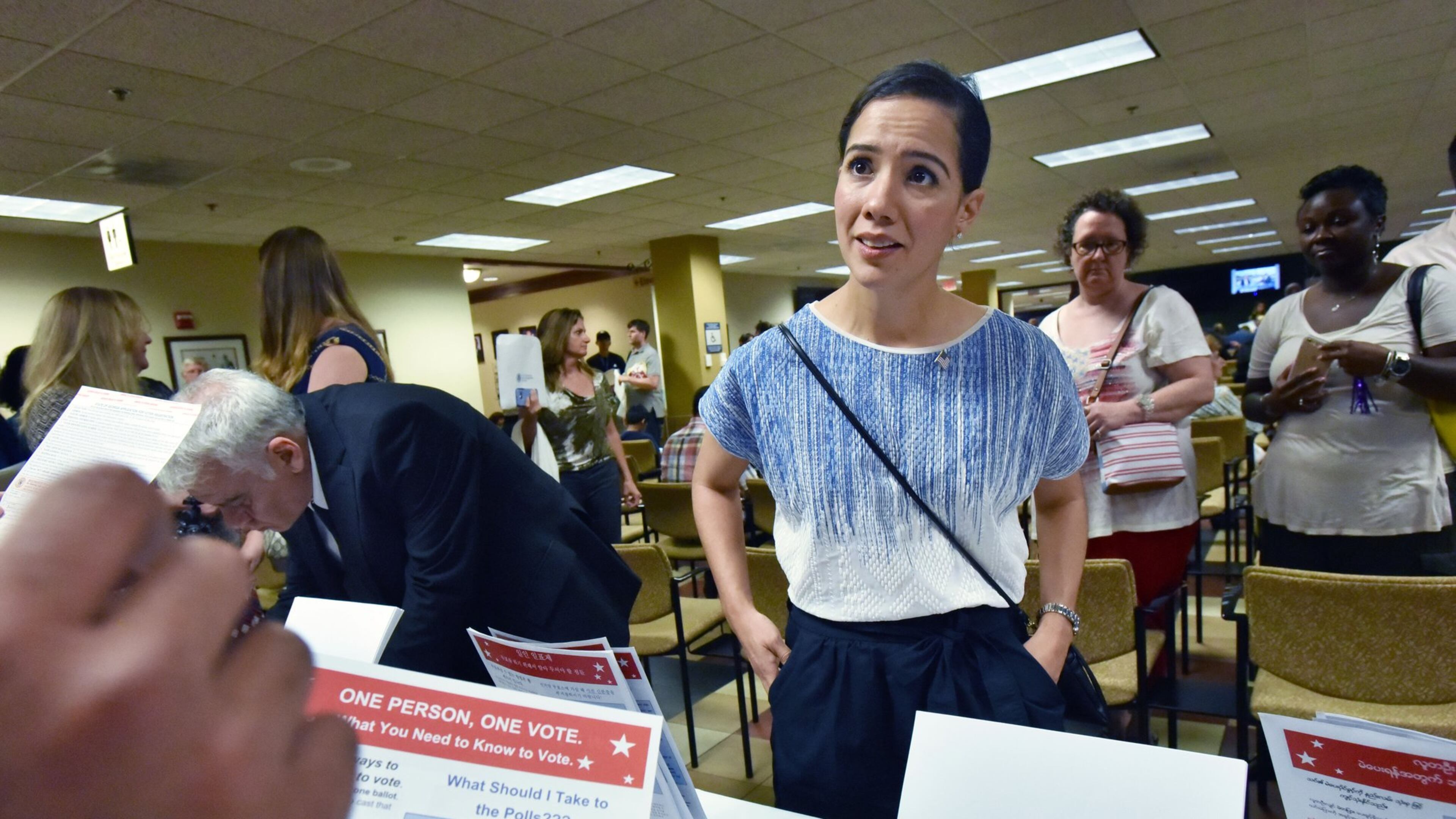 Newly naturalized citizen Perla Freed, originally from Honduras, completes her voting registration helped by Samuel Aguilar (left, showing hand), with Georgia Association of Latino Elected Officials, after her naturalization ceremony at the USCIS Atlanta Field Office on Friday, June 17, 2016. HYOSUB SHIN / HSHIN@AJC.COM