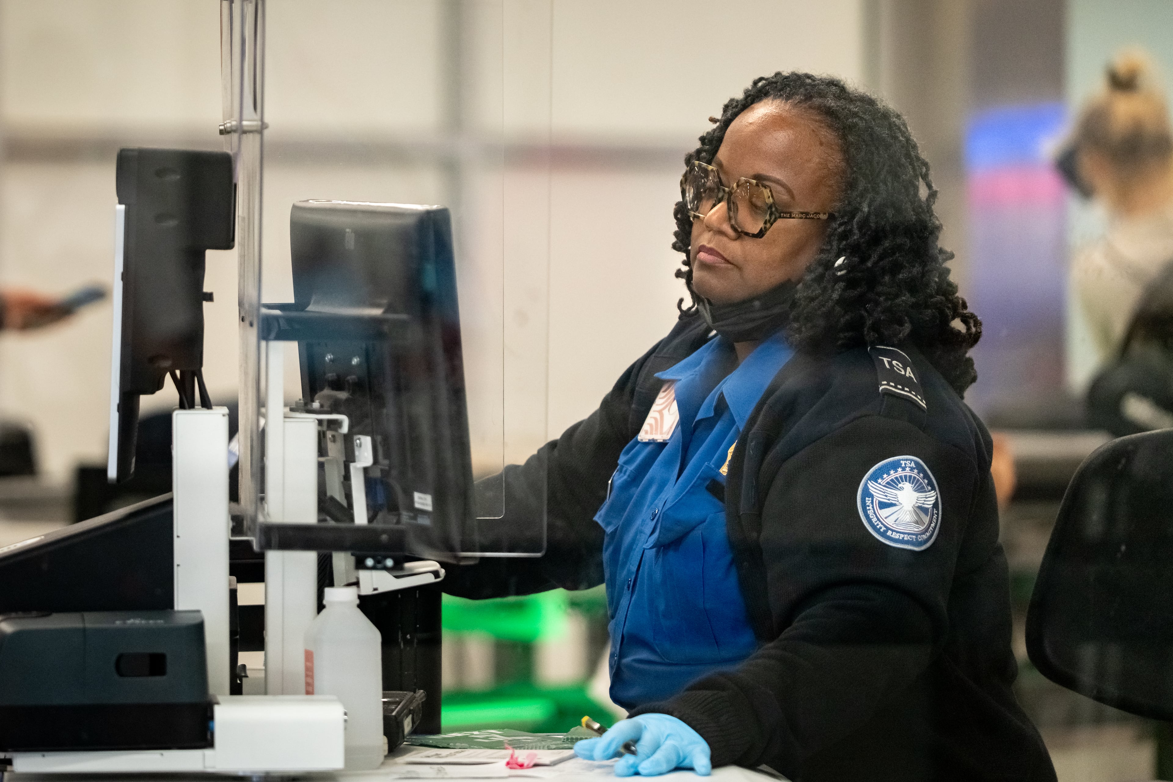 A TSA agent checks the identification of travelers at Hartsfield-Jackson Atlanta International Airport. Unlike past government closures, the threats of large-scale layoffs during the shutdown by the Trump administration are adding a new layer of stress, according to a TSA union leader. (Ben Hendren for the AJC)