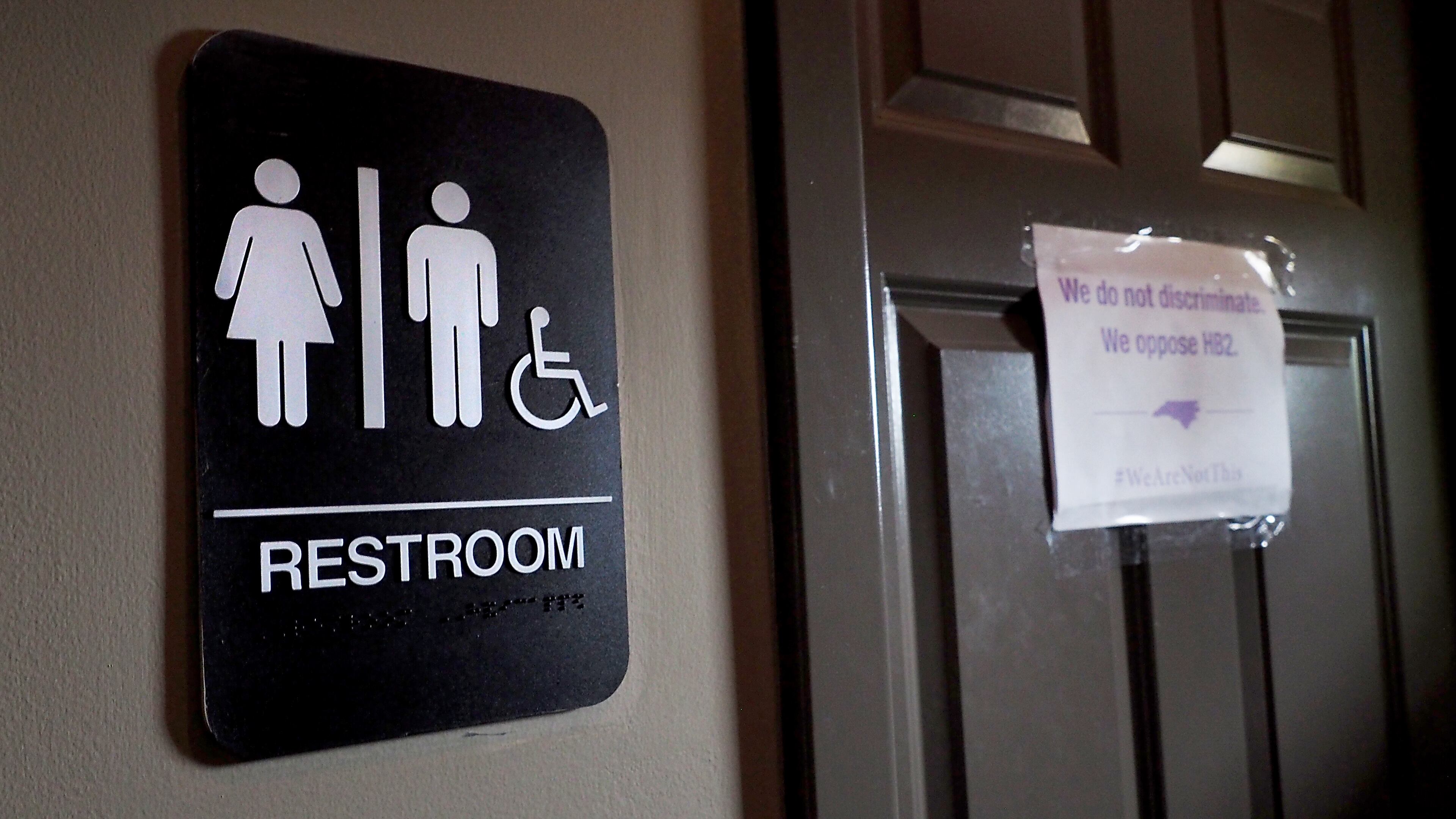 DURHAM, NC - MAY 10: A unisex sign and the 'We Are Not This' slogan are outside a bathroom at Bull McCabes Irish Pub on May 10, 2016 in Durham, North Carolina. Debate over transgender bathroom access spreads nationwide as the U.S. Department of Justice countersues North Carolina Governor Pat McCrory from enforcing the provisions of House Bill 2 that dictate what bathrooms transgender individuals can use. (Photo by Sara D. Davis/Getty Images)