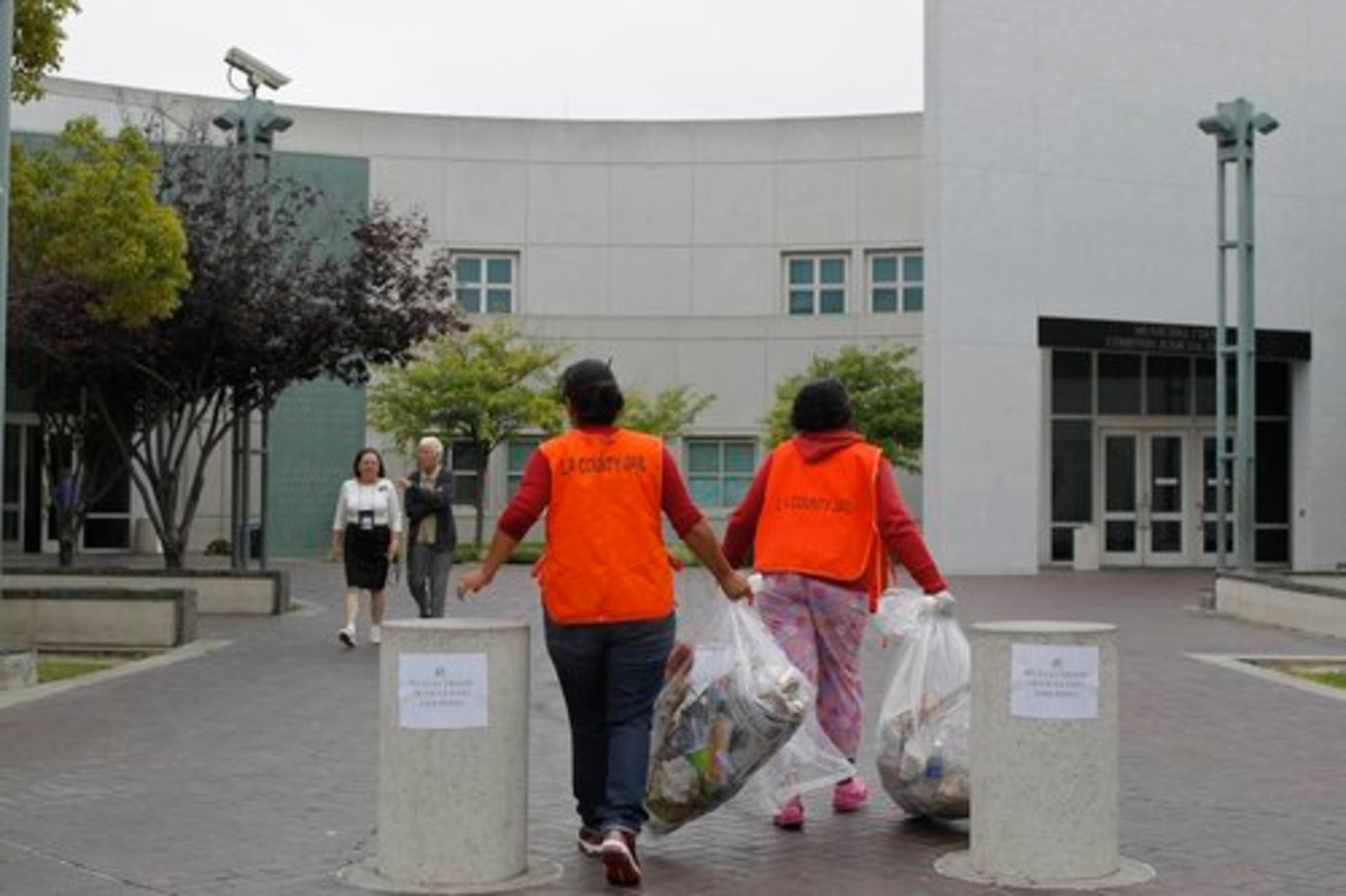 Inmates pick up trash cans outside the Century Regional Detention Facility Century Sheriff Station, where Lindsay Lohan is expected to serve her sentence.