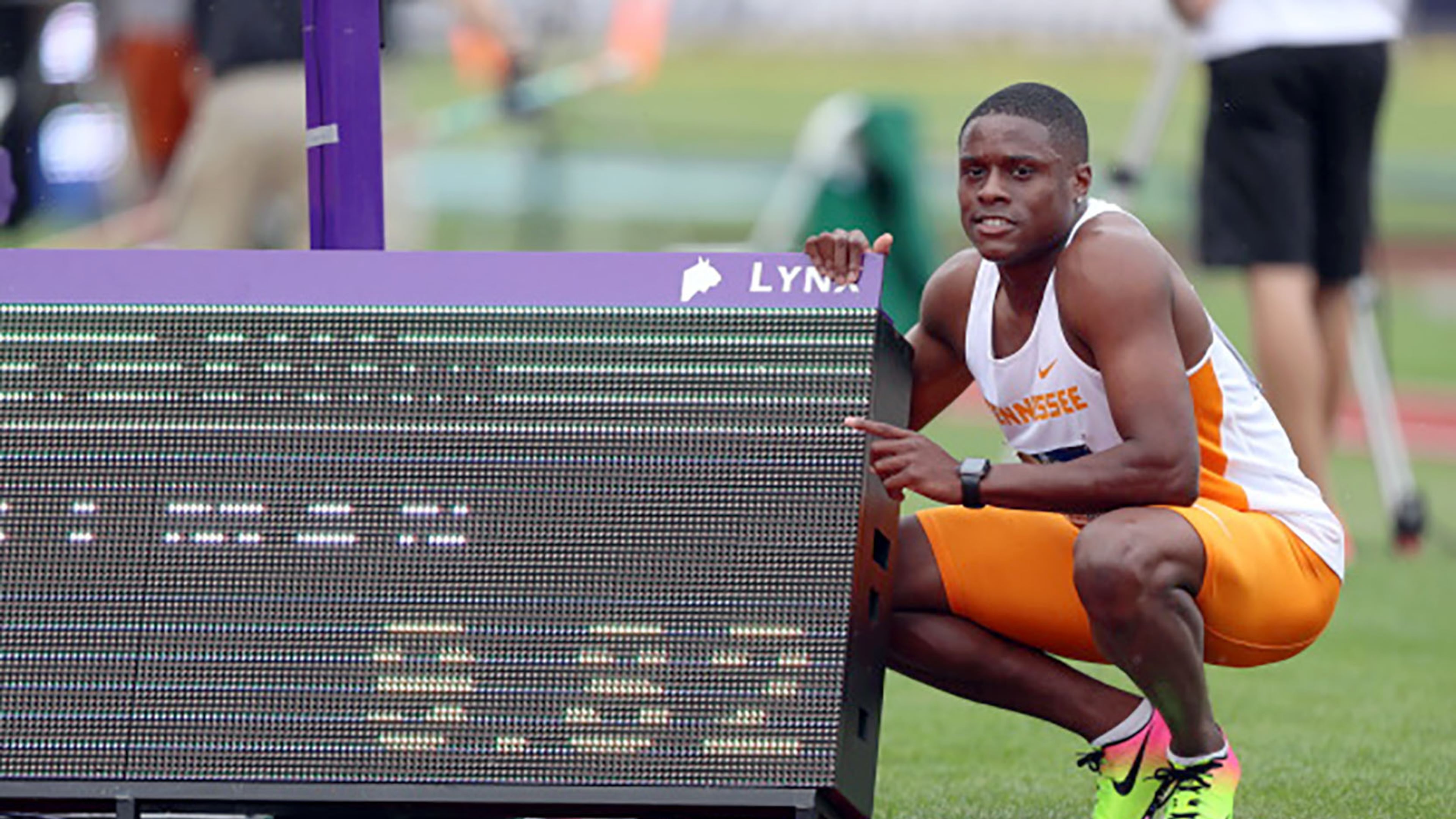 Christian Coleman poses next to his record time scoreboard Wednesday during the NCAA track and field championships at Hayward Field in Eugene, Oregon. Photo By Donald Page/Tennessee Athletics