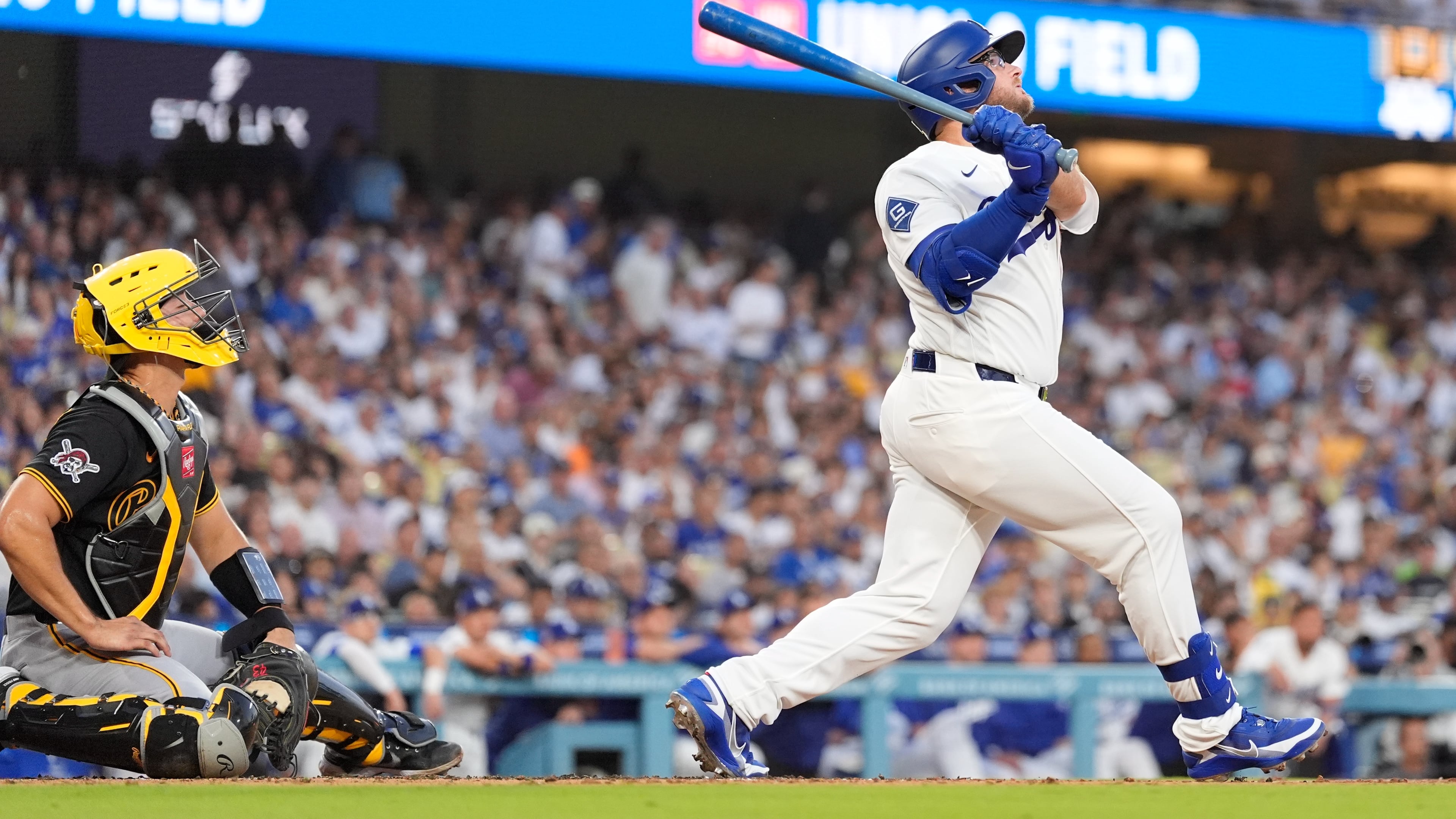 Los Angeles Dodgers' Max Muncy, right, hits a two-run home run as Pittsburgh Pirates catcher Rafael Flores Jr. watches during the first inning of a baseball game Friday, Aug. 21, 2026, in Los Angeles. (AP Photo/Mark J. Terrill)