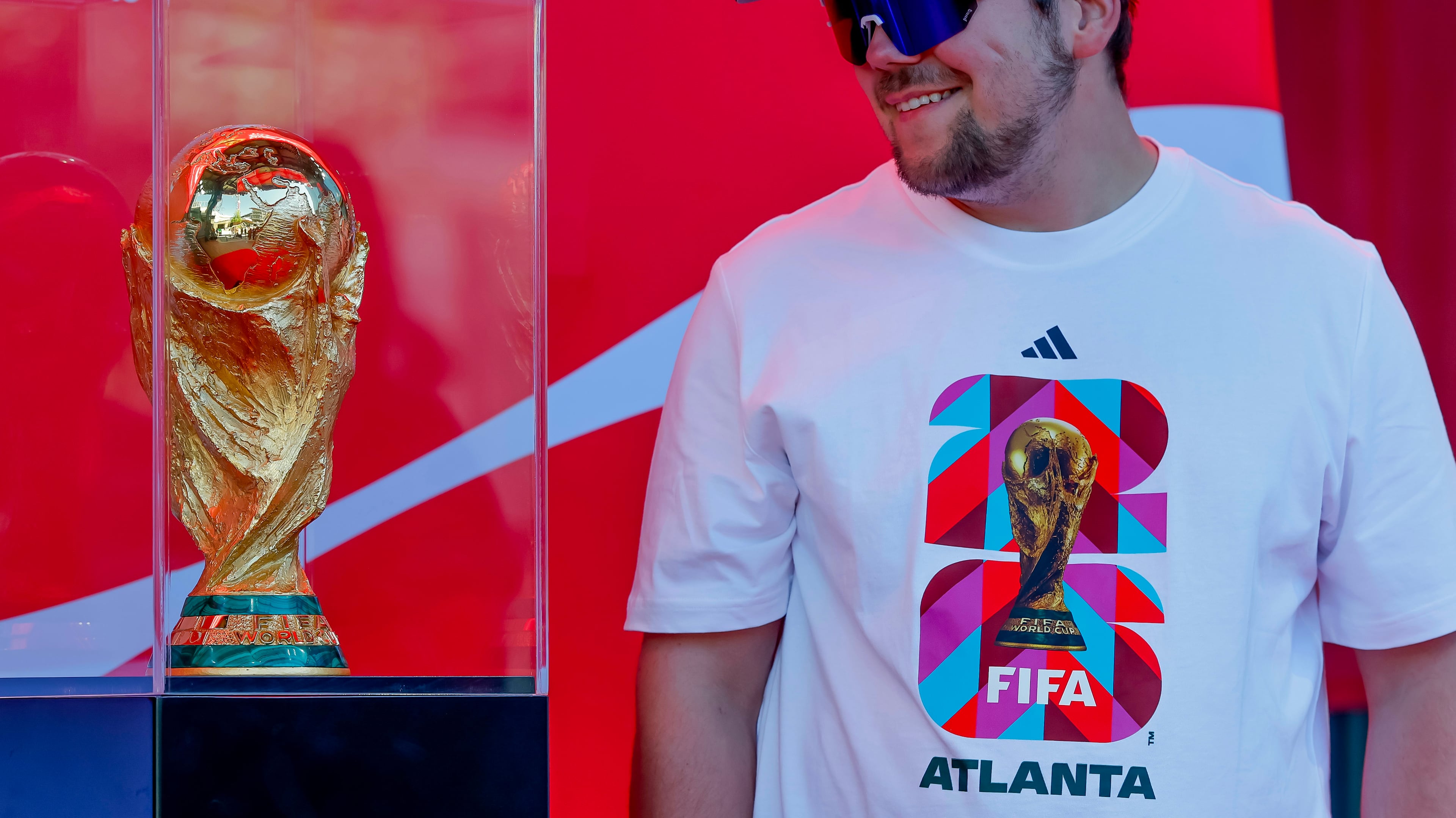 Soccer fan Joseph Pozdnakov has his photo taken during the FIFA World Cup Trophy Tour outside Truist Park before the Atlanta Braves host the Chicago Cubs in a baseball game, Thursday, May 14, 2026, in Atlanta. Eight FIFA World Cup soccer matches will be played in Atlanta.(AP Photo/Erik S. Lesser)