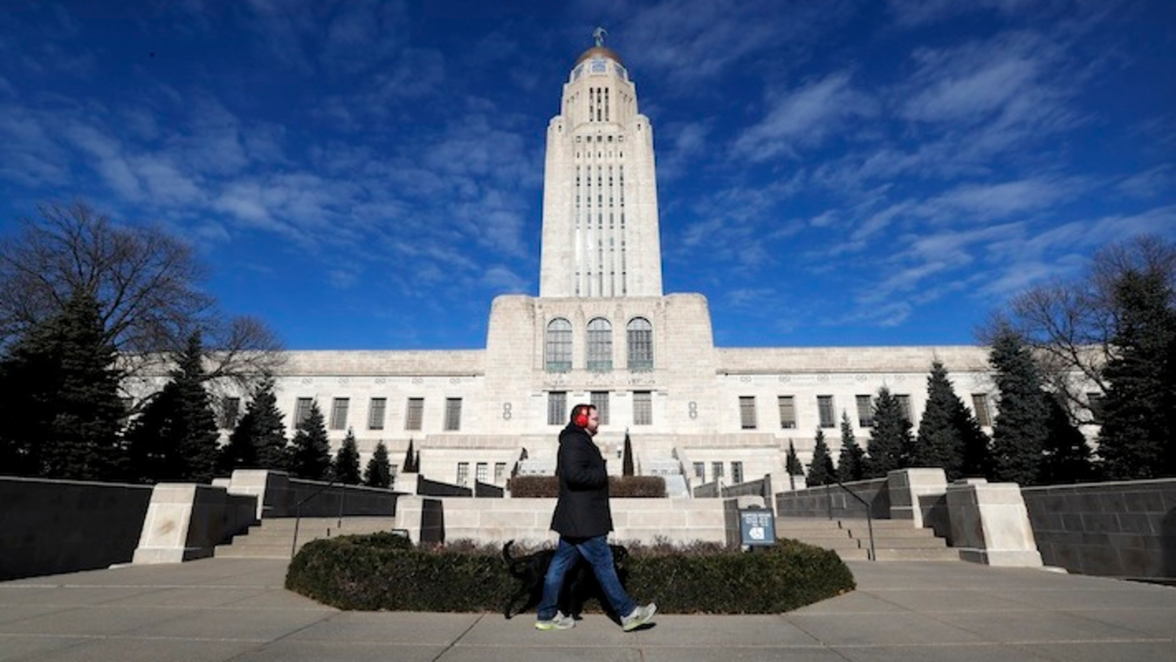 A pedestrian walks past the Nebraska State Capitol building in Lincoln, Neb., on Wednesday, Jan. 4, 2017. Lancaster County is among the most evenly split on political lines of any major county in the nation. (AP Photo/Charlie Neibergall)