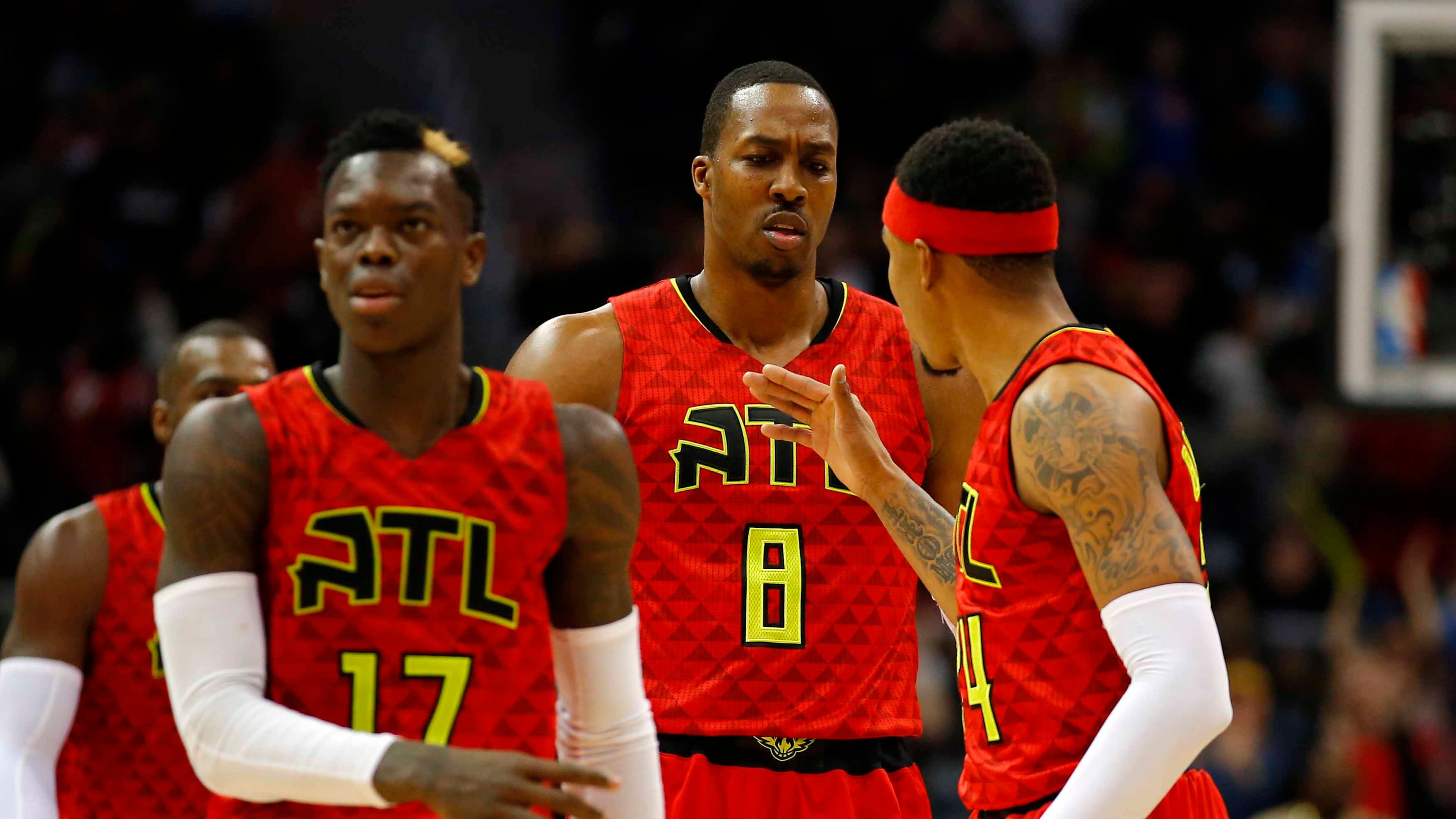 Atlanta Hawks center Dwight Howard (8) reacts with teammates guard Dennis Schroder (17) and forward Kent Bazemore (24) after his dunk in the second half of an NBA basketball game against the New York Knicks on Sunday, Jan. 29, 2017, in Atlanta. The Hawks won the game in the fourth overtime 142-139. (AP Photo/Todd Kirkland)