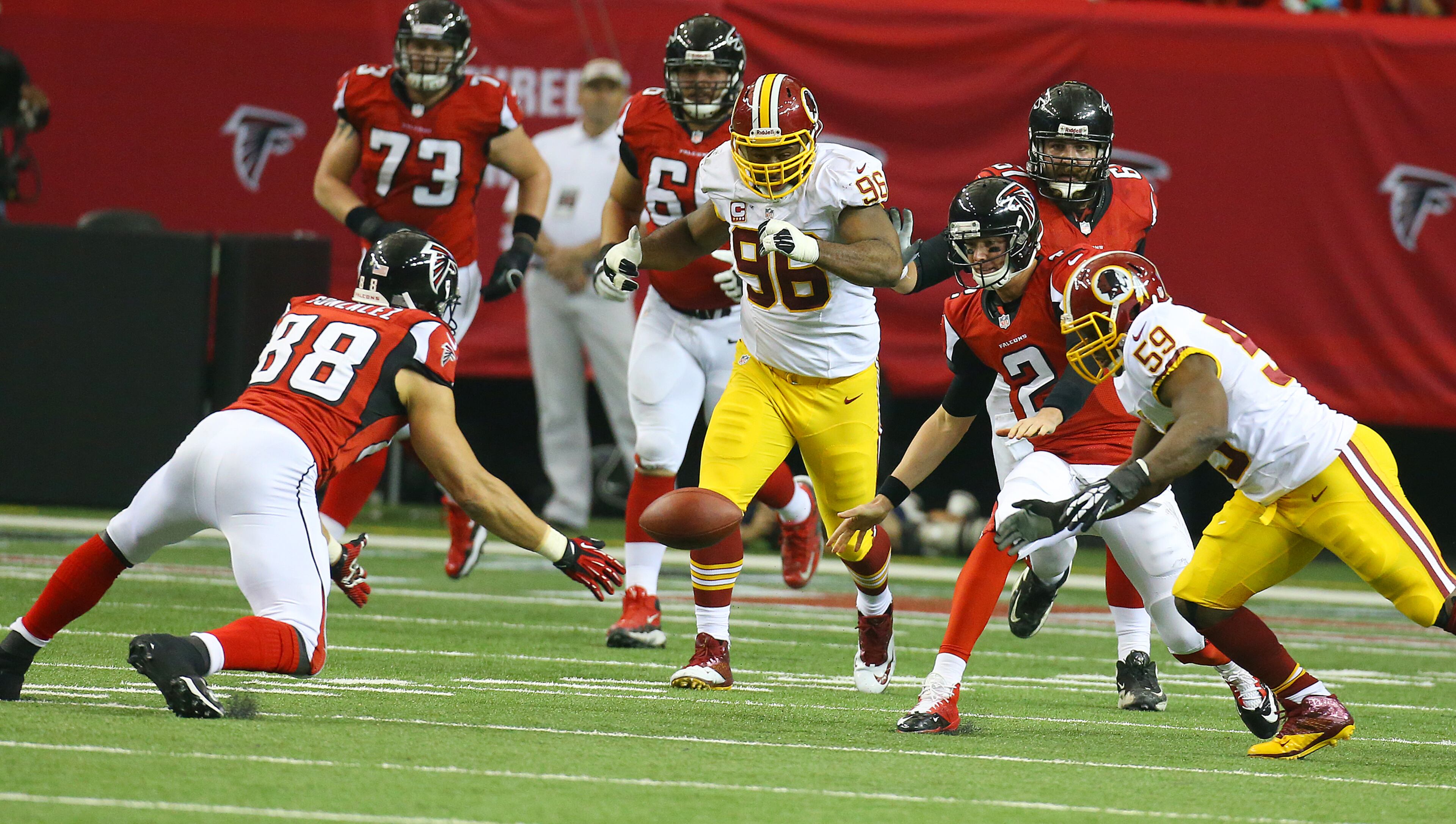 Falcons tight end Tony Gonzalez recovers what appeared to be a fumble by quarterback Matt Ryan (right) during 1st half action against the Redskins in a NFL football game on Sunday, Dec. 15, 2013, in Atlanta. Officials ruled it was an illegal forward pass attempt after reviewing the play.