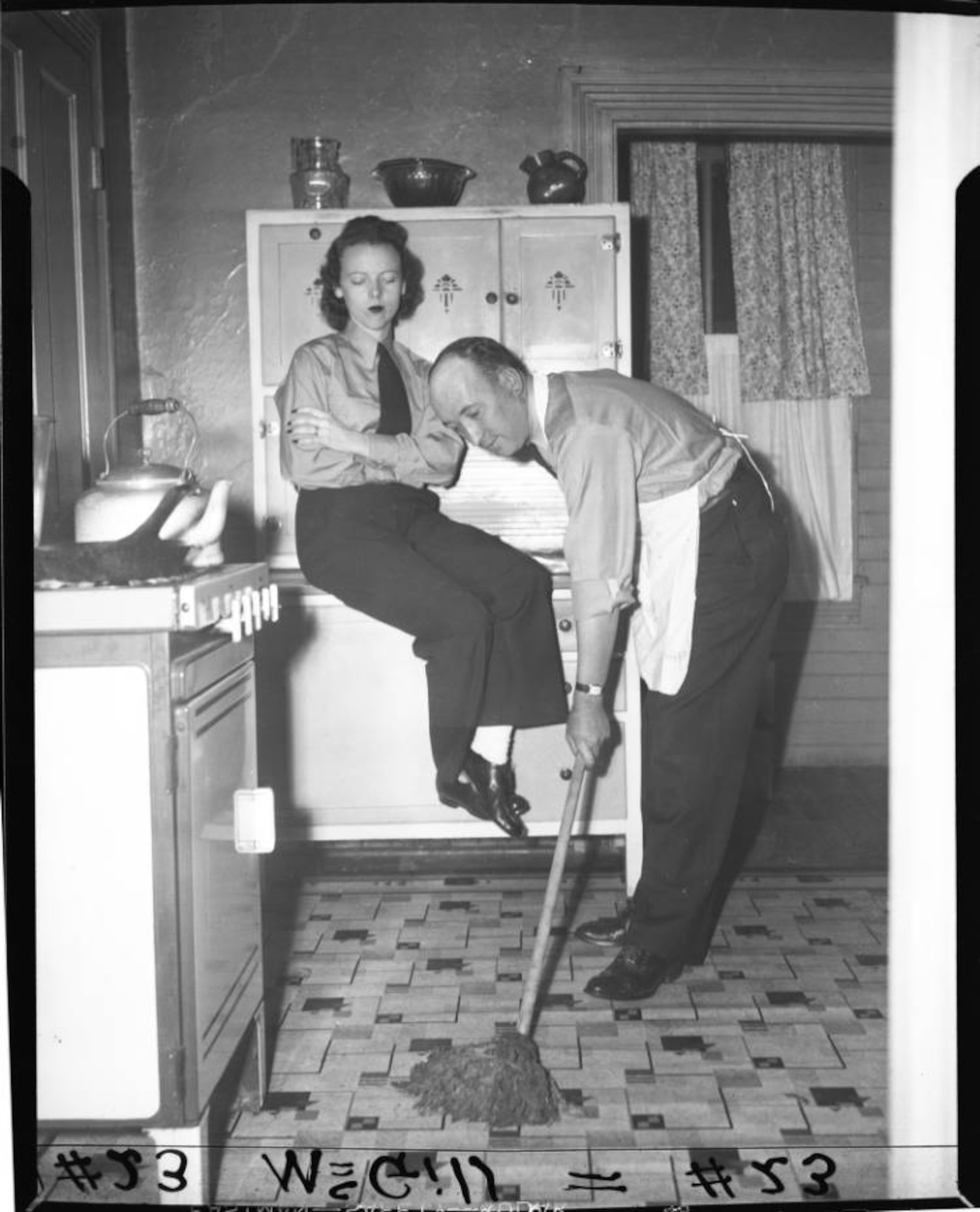 Street car operator watching a man mop the kitchen floor in Atlanta in January 1945. AJC file