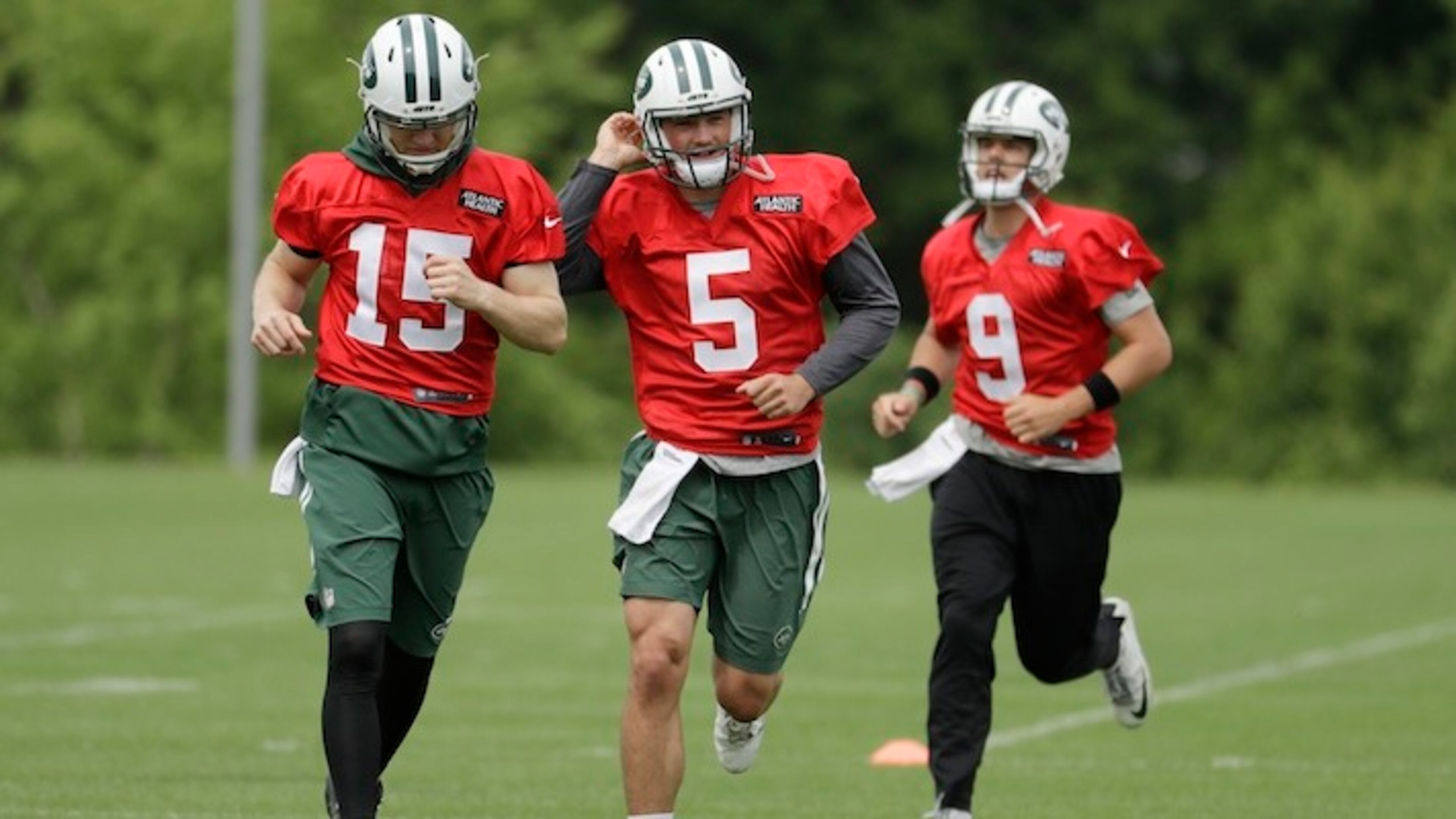 New York Jets quarterbacks, from left, Josh McCown, Christian Hackenberg and Bryce Petty jog during the team's organized team activities at its NFL football training facility, Tuesday, May 23, 2017, in Florham Park, N.J. (AP Photo/Julio Cortez)