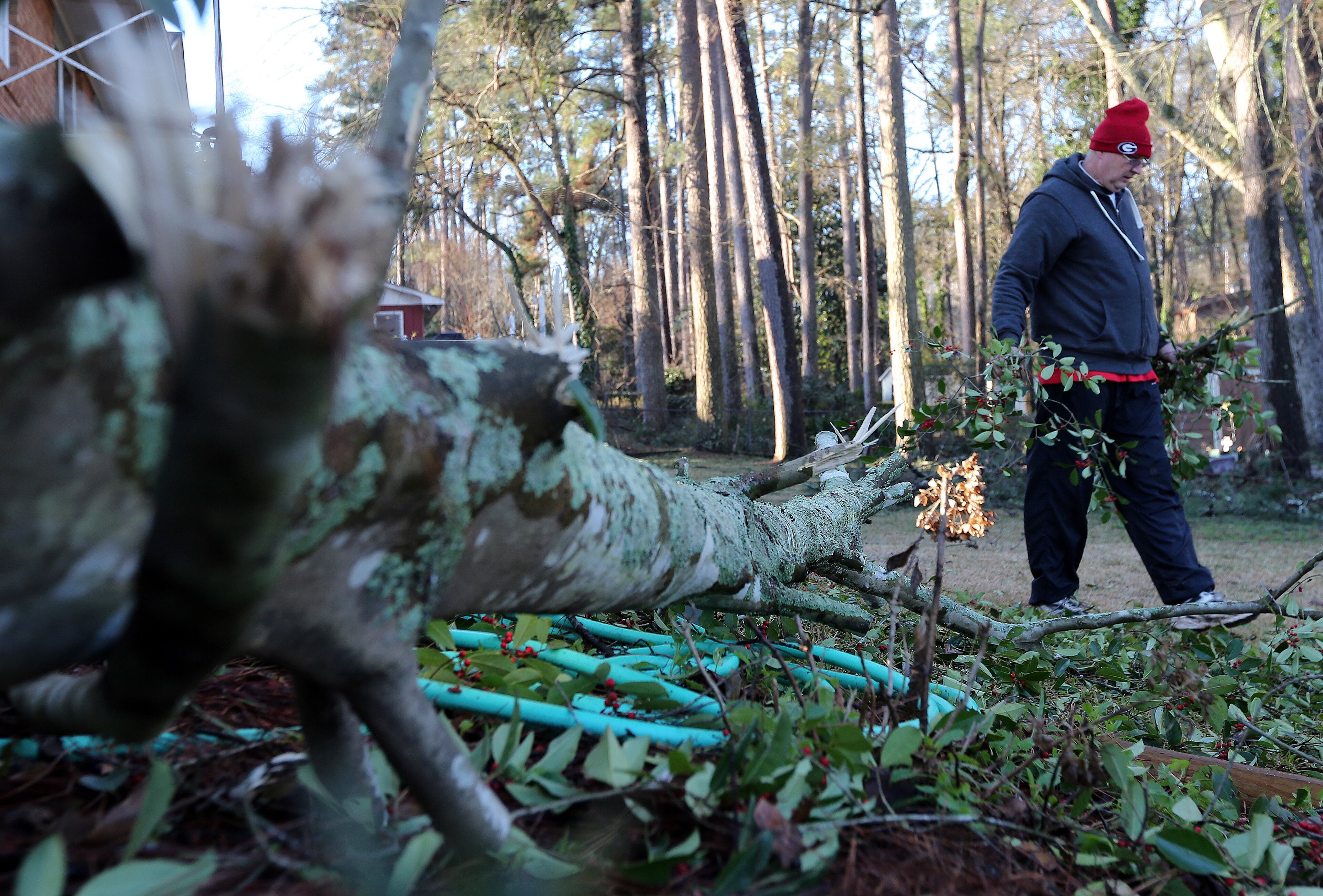 Steve Lariscy hauls pine branches to the curb as he works to clean up his yard in Augusta early Saturday morning February 15, 2014 while waiting for power to be restored to his house. BEN GRAY / BGRAY@AJC.COM