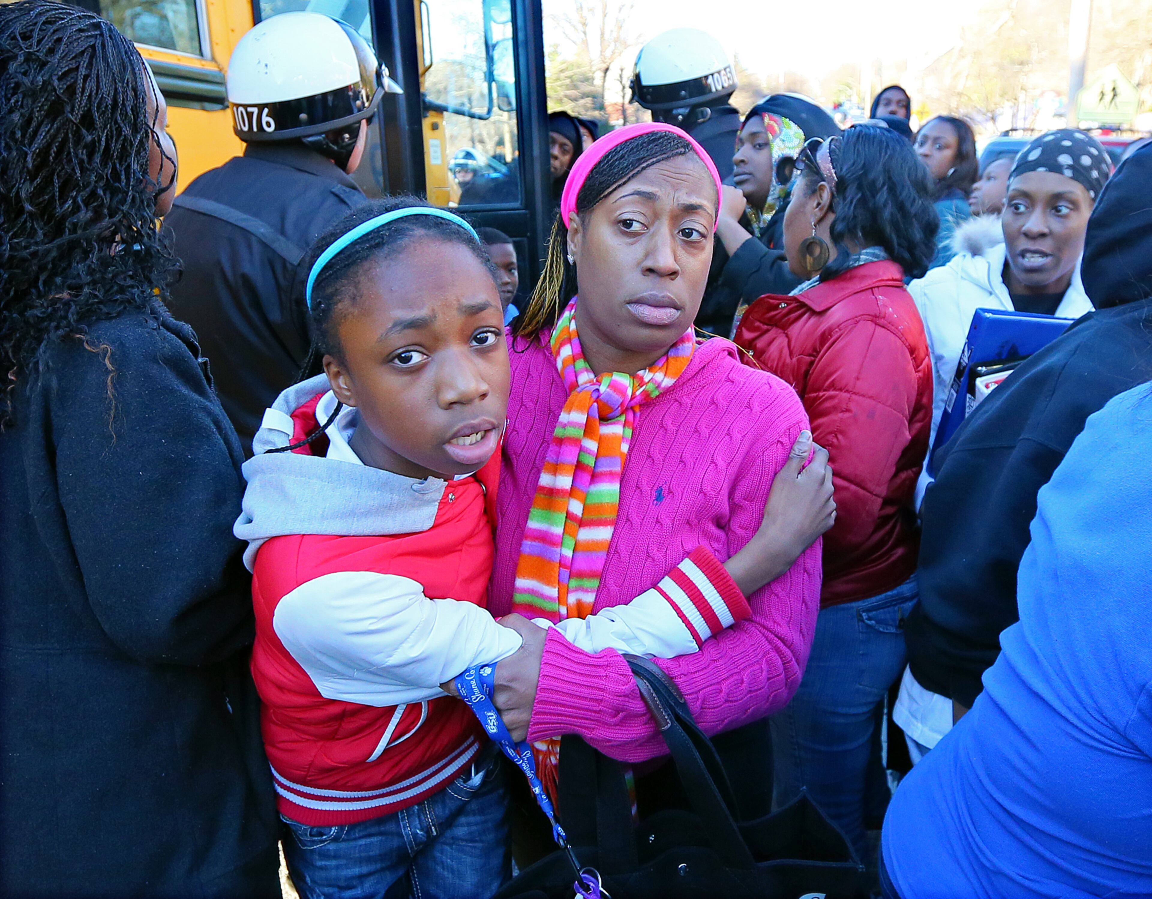 Tiffany Myricle, 37, leads daughter Xavia Denise Myricle, 12, away from her bus as parents and children are reunited at the church.