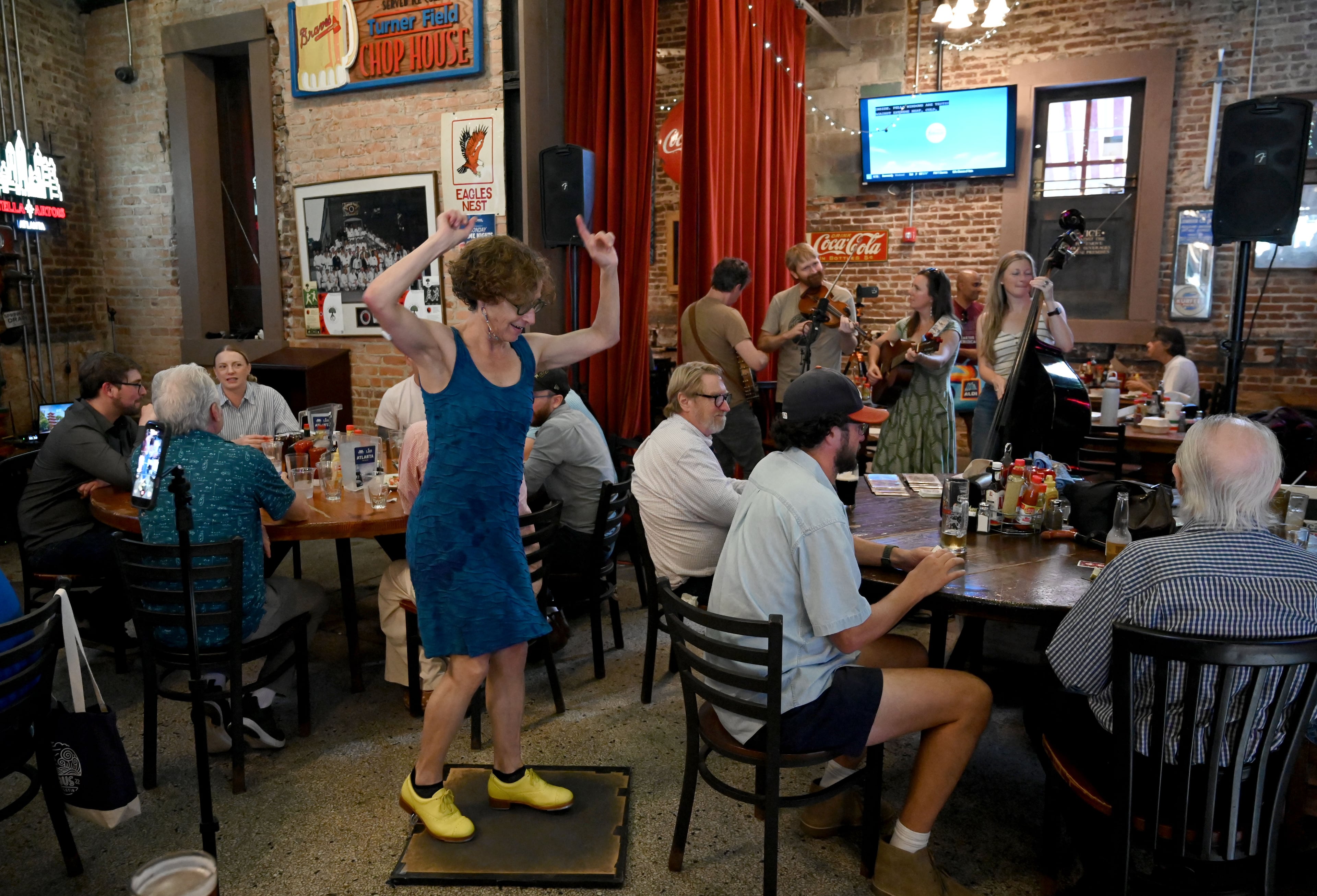 Content creator Miss Moonshine dances as The Four O’Clocks performs during Manuel’s Tavern’s 70th anniversary celebration. (Hyosub Shin/AJC)