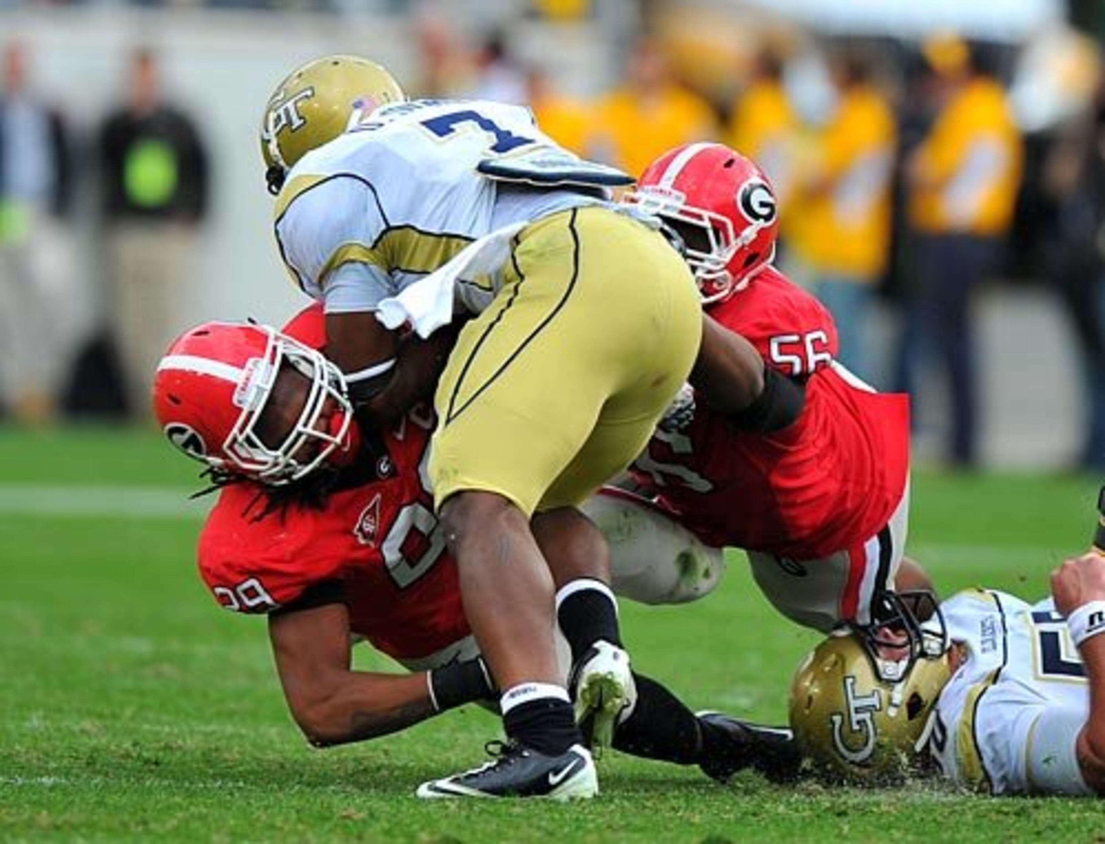 Georgia Tech's David Sims tries to barrel through Georgia's Jarvis Jones, left, and Garrison Smith.