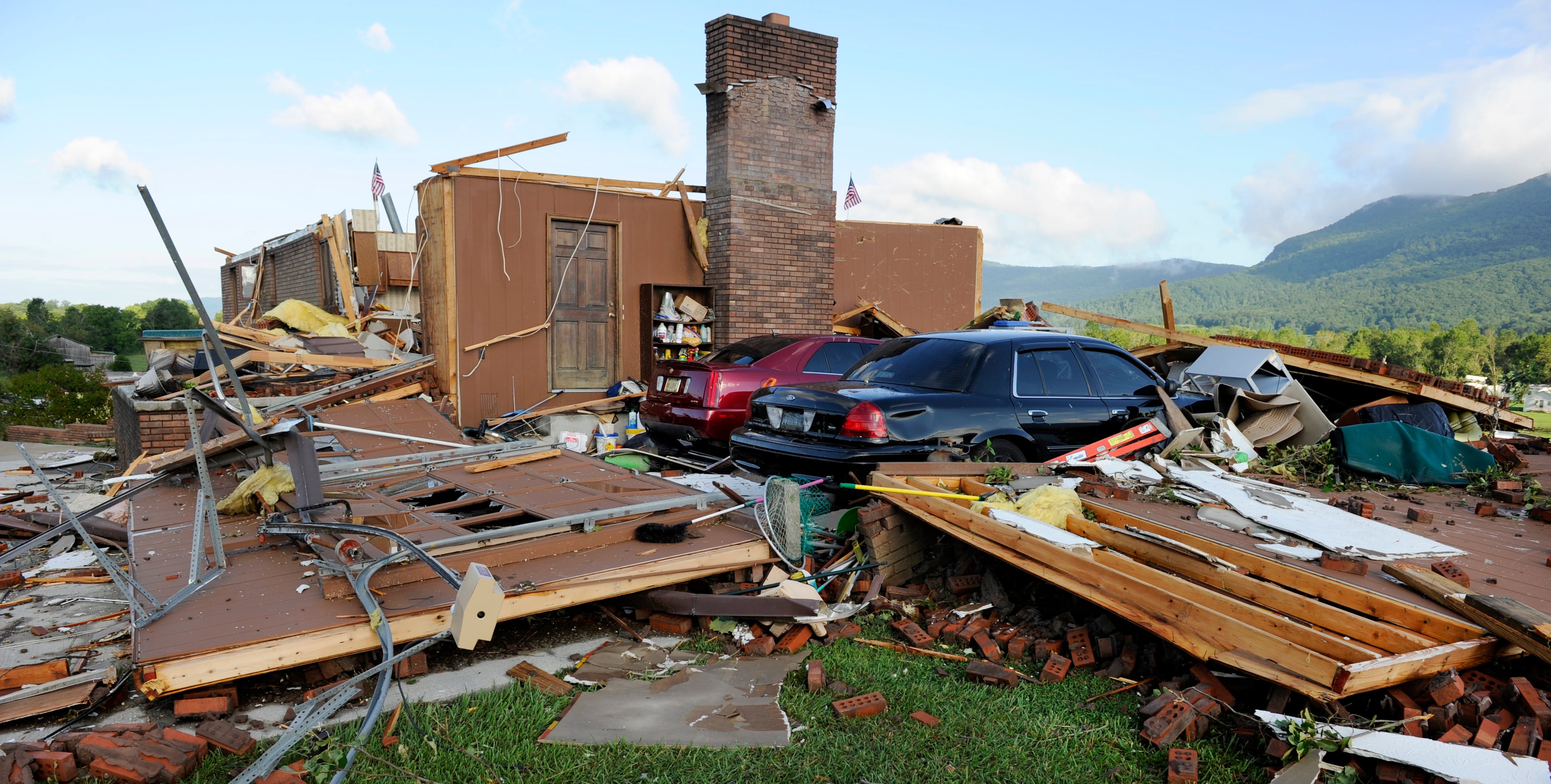 Debris is scattered by the storm-damaged home of Claiborne County Sheriff David Ray, Monday, July 28, 2014, near LaFollette, Tenn. The National Weather Service confirmed a F-3 tornado packing winds of 140 mph slammed into the Speedwell community, leveling 10 homes and a grocery store Sunday night.