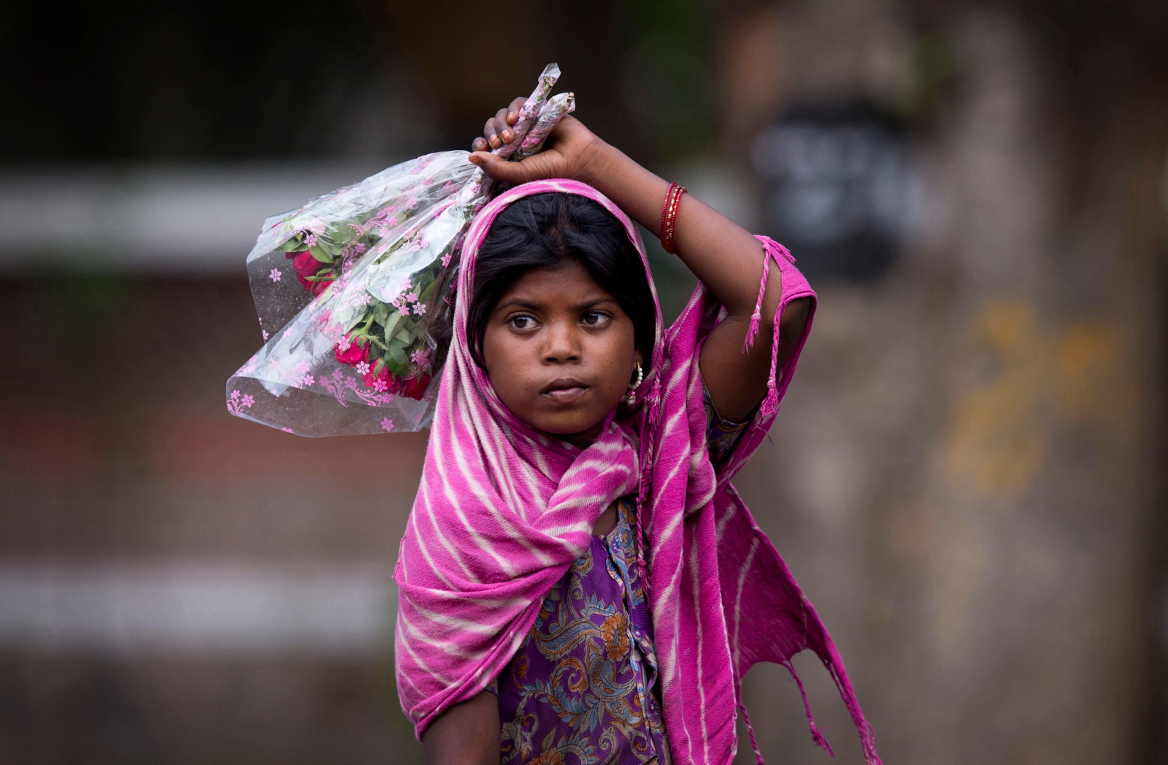 FLOWER SELLER--A young girl waits for cars to stop at the traffic light to sell flowers to commuters at a busy cross road in New Delhi, India, Wednesday, June 1, 2016. As they garner better sales due to sympathetic reasons, children are often forced by families to beg or sell small items for hours irrespective of weather conditions. (AP Photo/Saurabh Das)