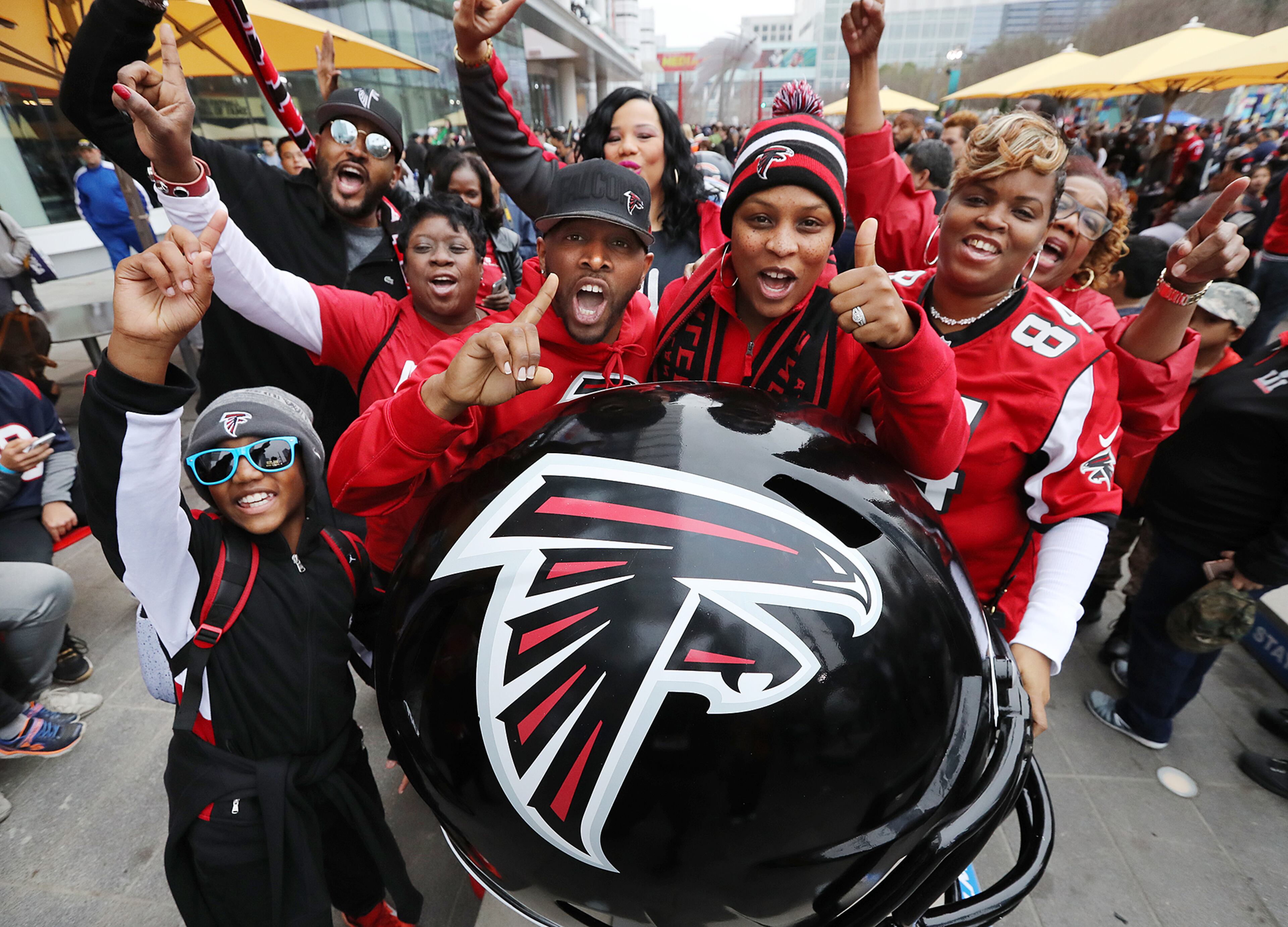 February 4, 2017, Houston: Everett and Chaunecey Richards (center) and their group of fans from Atlanta get rowdy the night before the Super Bowl while gathering at the team helmet during a visit to the NFL Experience and Super Bowl Live on Saturday Feb. 4, 2017, in Houston. Curtis Compton/ccompton@ajc.com